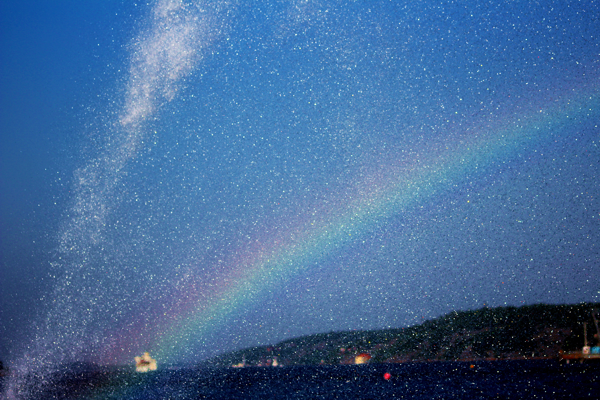 Regnbågen mot en mörkblå himmel