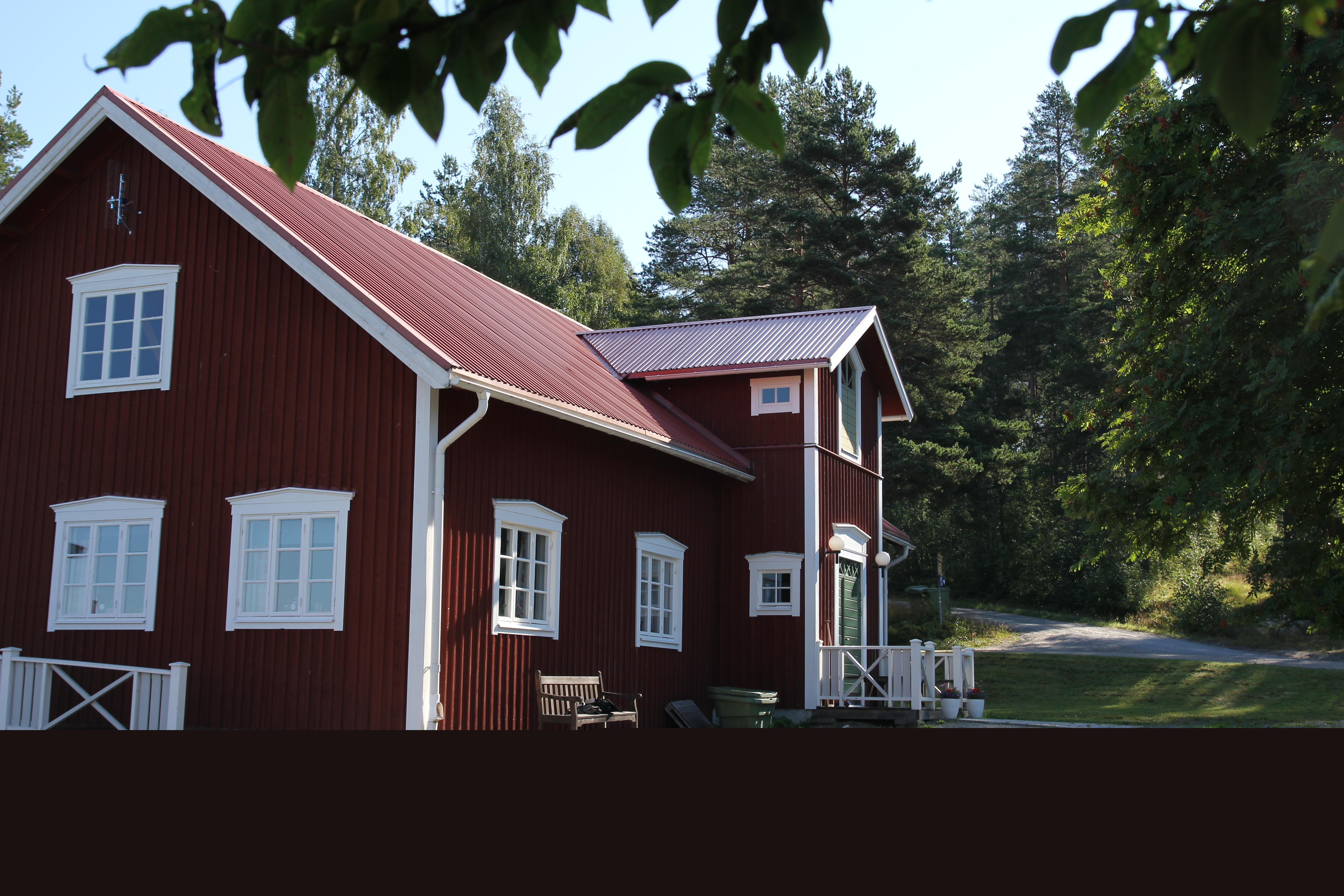 Lägergårdens huvudbyggnad med kök, matsal, samlingssal med öppen spis och en veranda med utsikt mot sjön.