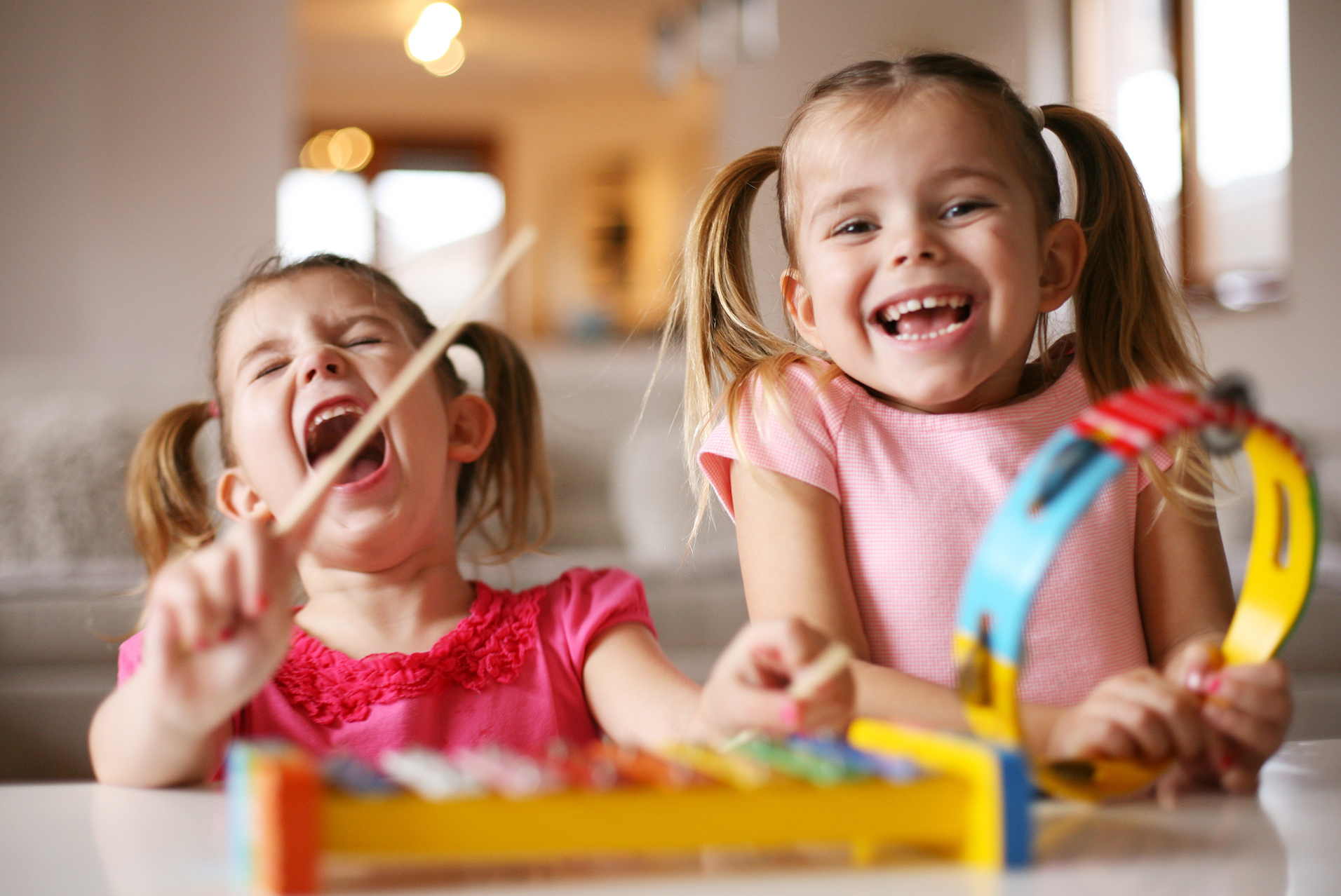 Två barn står bakom ett bord och håller i instrument. 