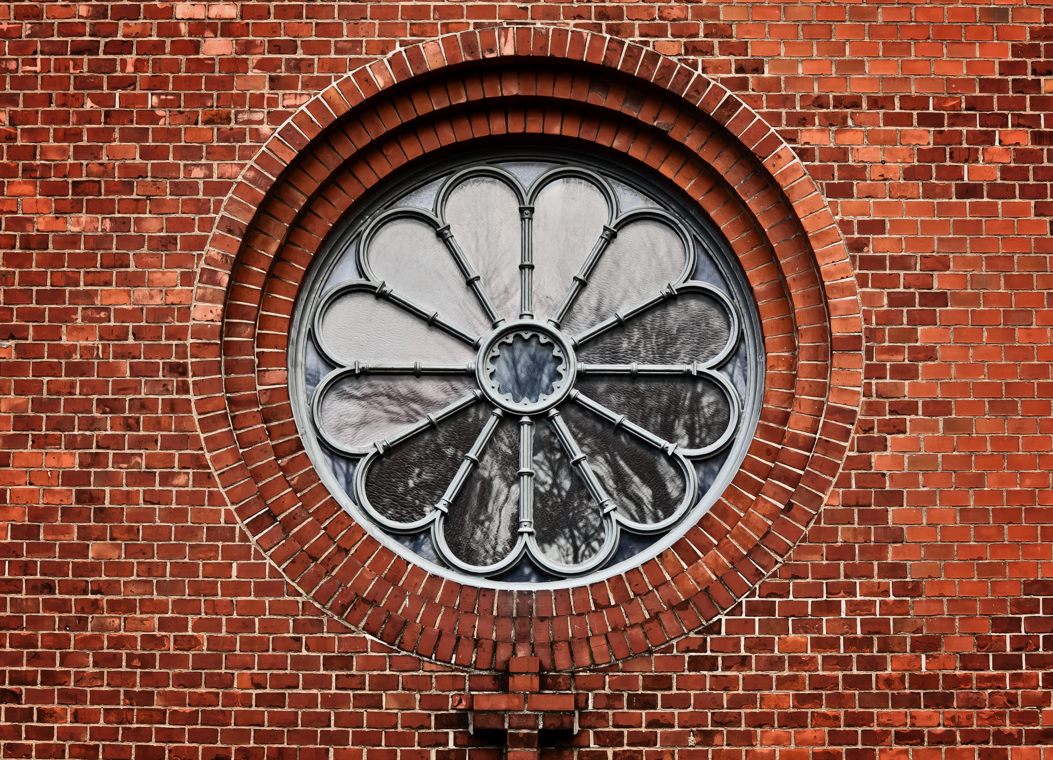 Ett rosettfönster på en tegelfasad.