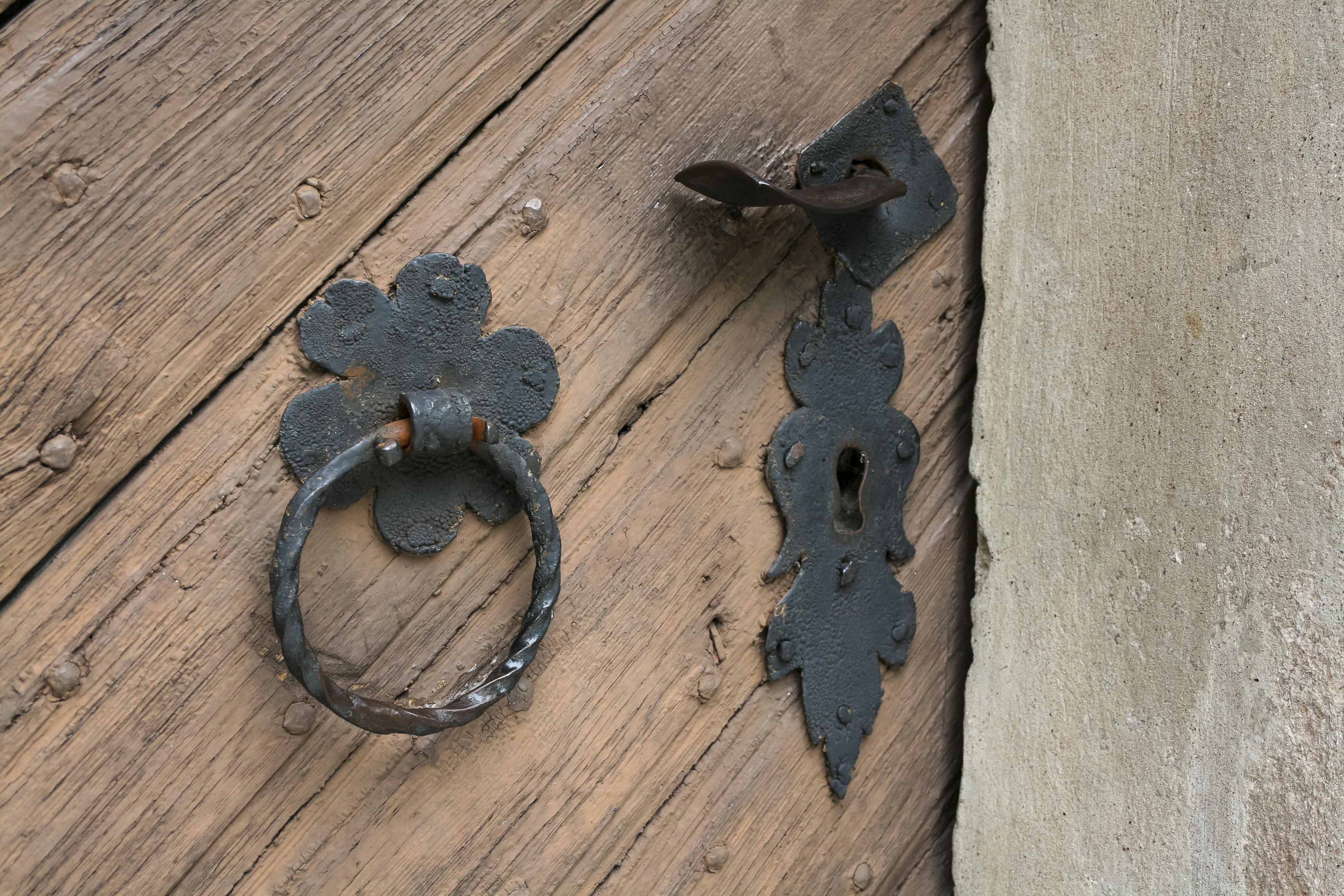 En portklapp och ett nyckelhål på en gammal trädörr.