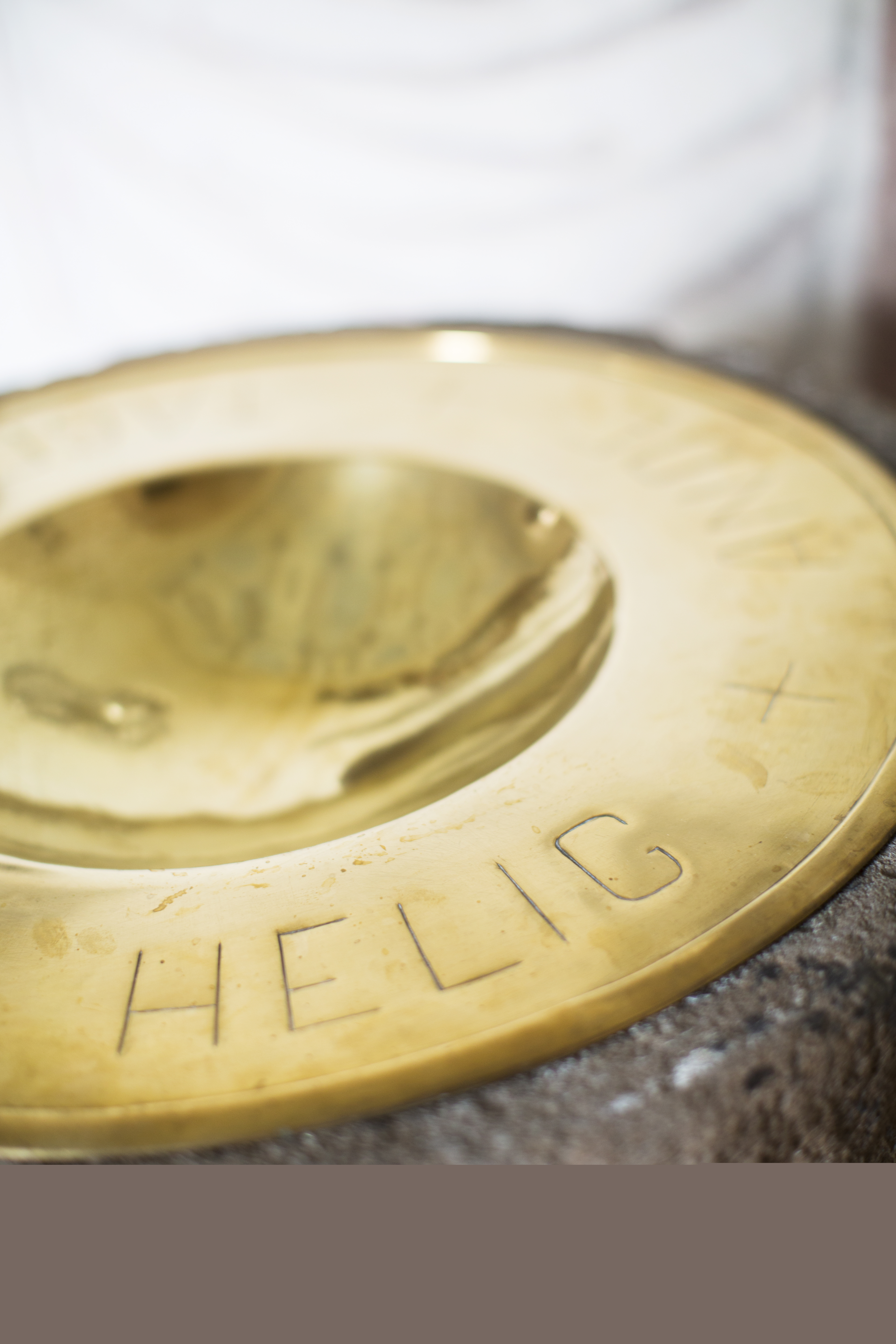 En guldig dopfunt med texten Helig.