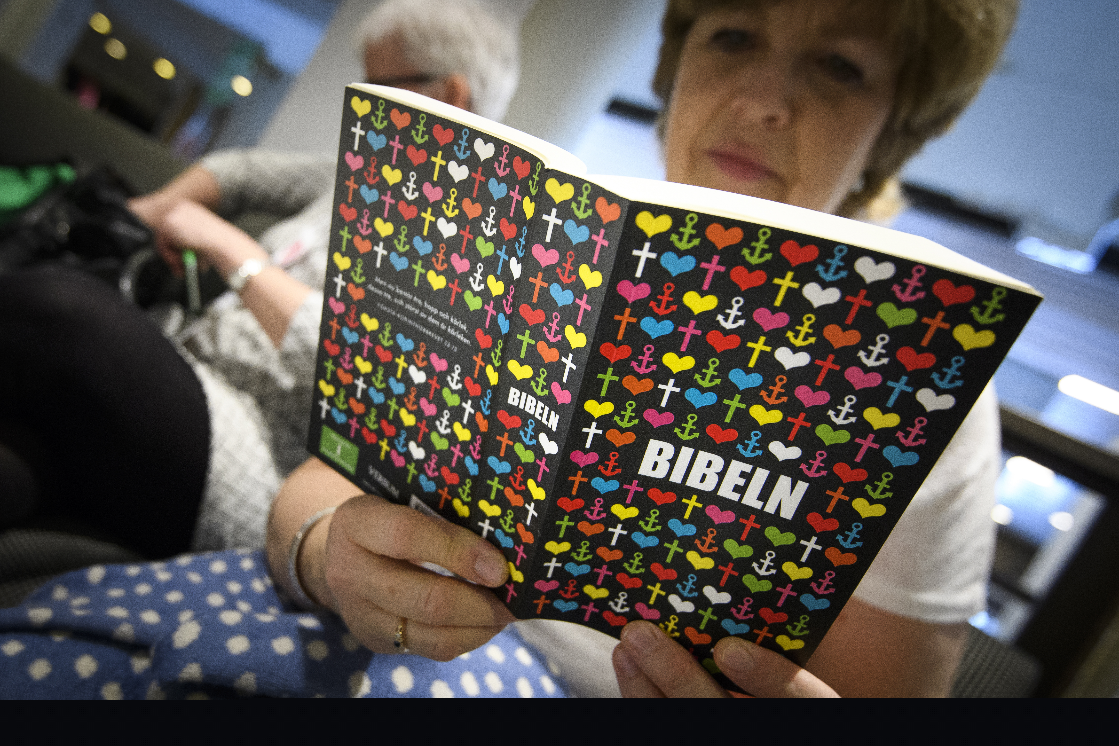 En äldre kvinna läser en bibel.