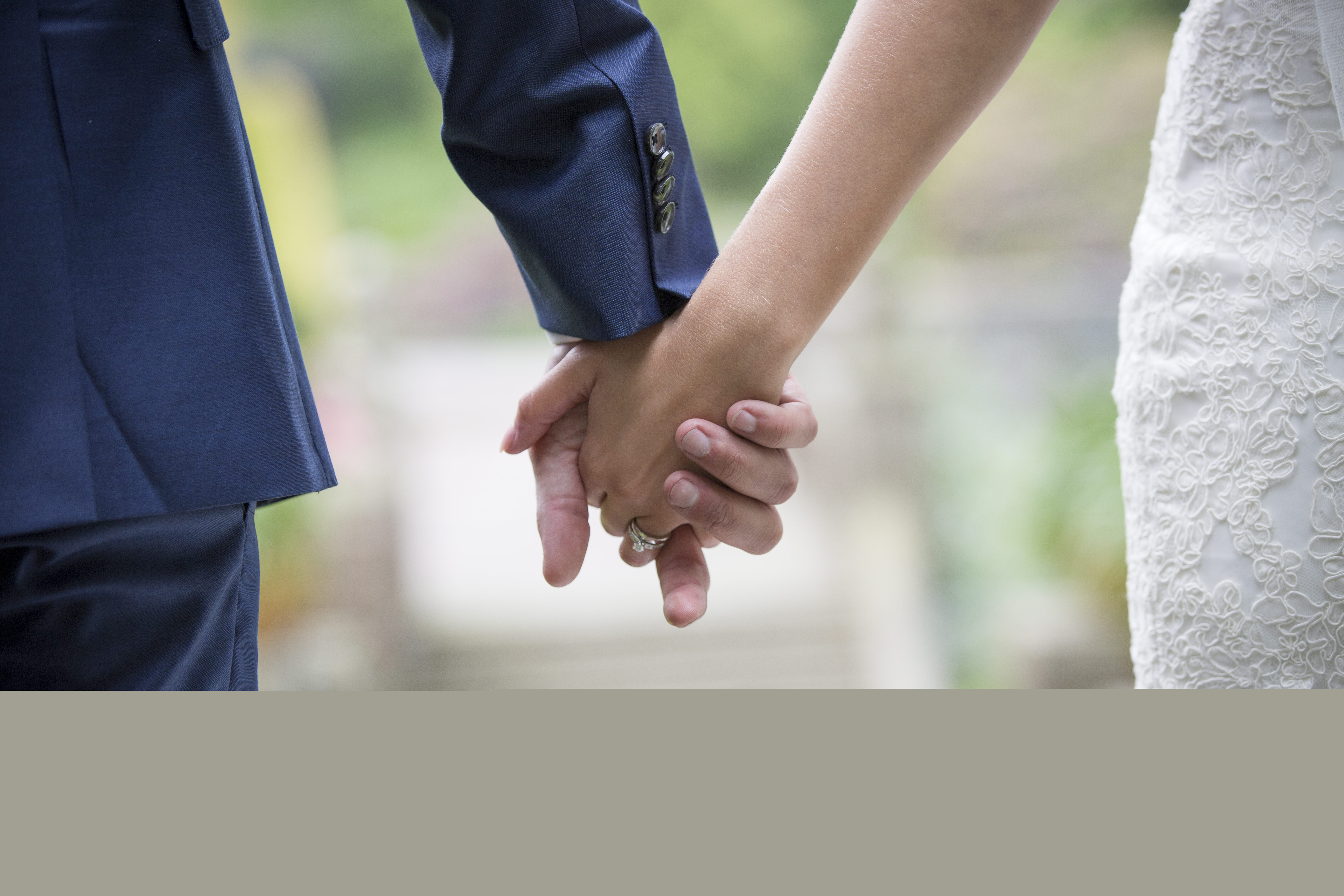 Ett brudpar som håller hand.