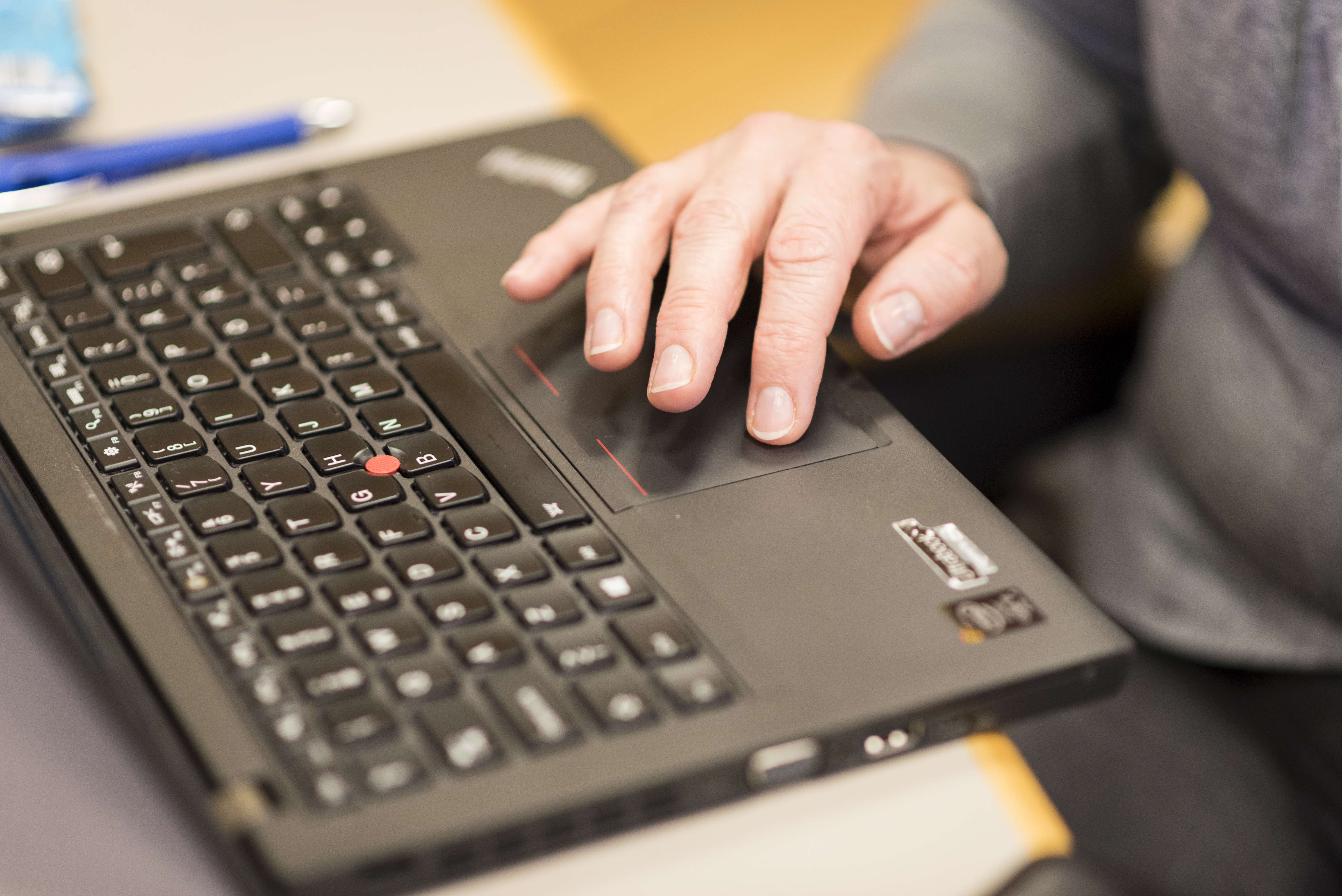 En person sitter och arbetar på sin laptop.