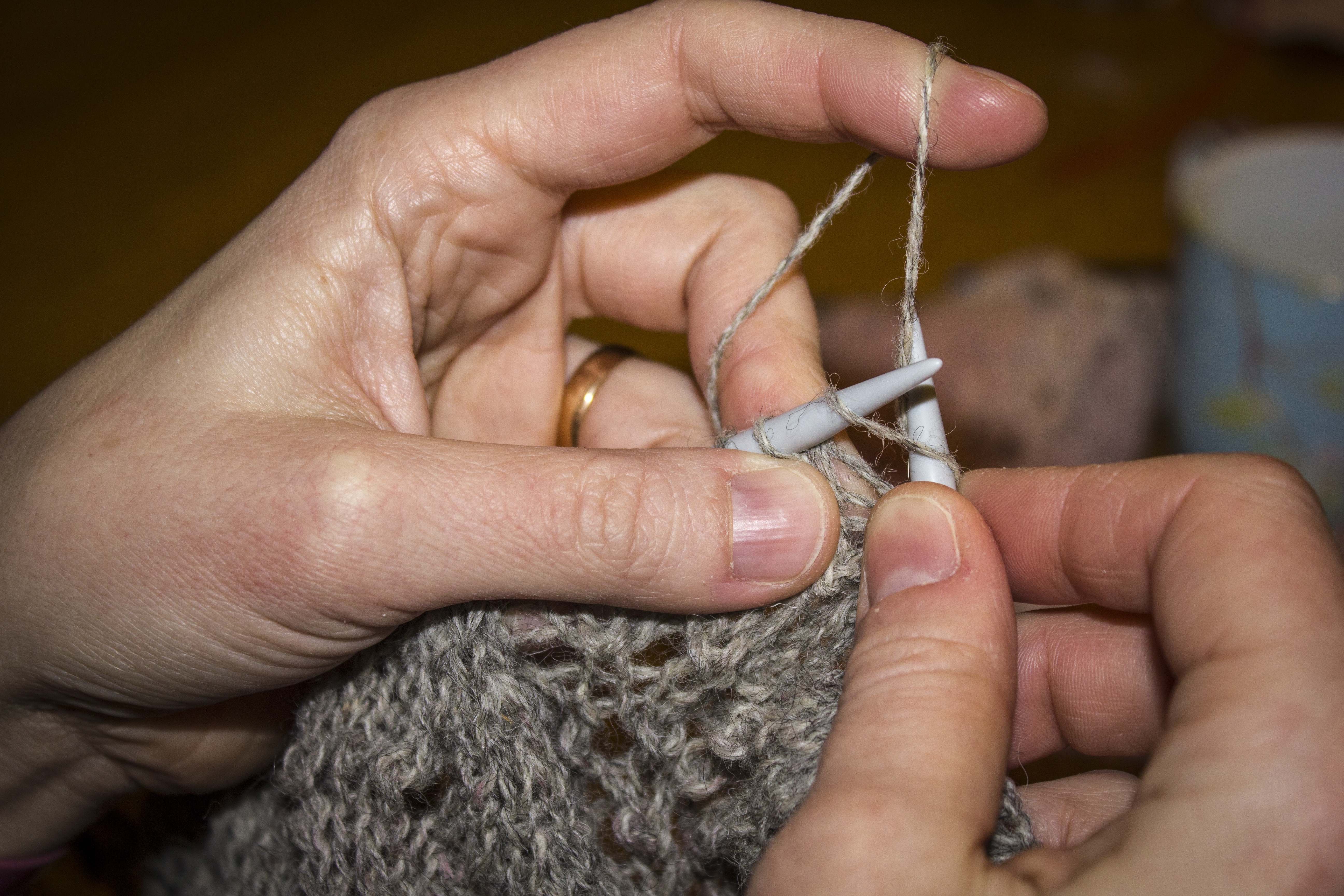 Närbild på händer som stickar.