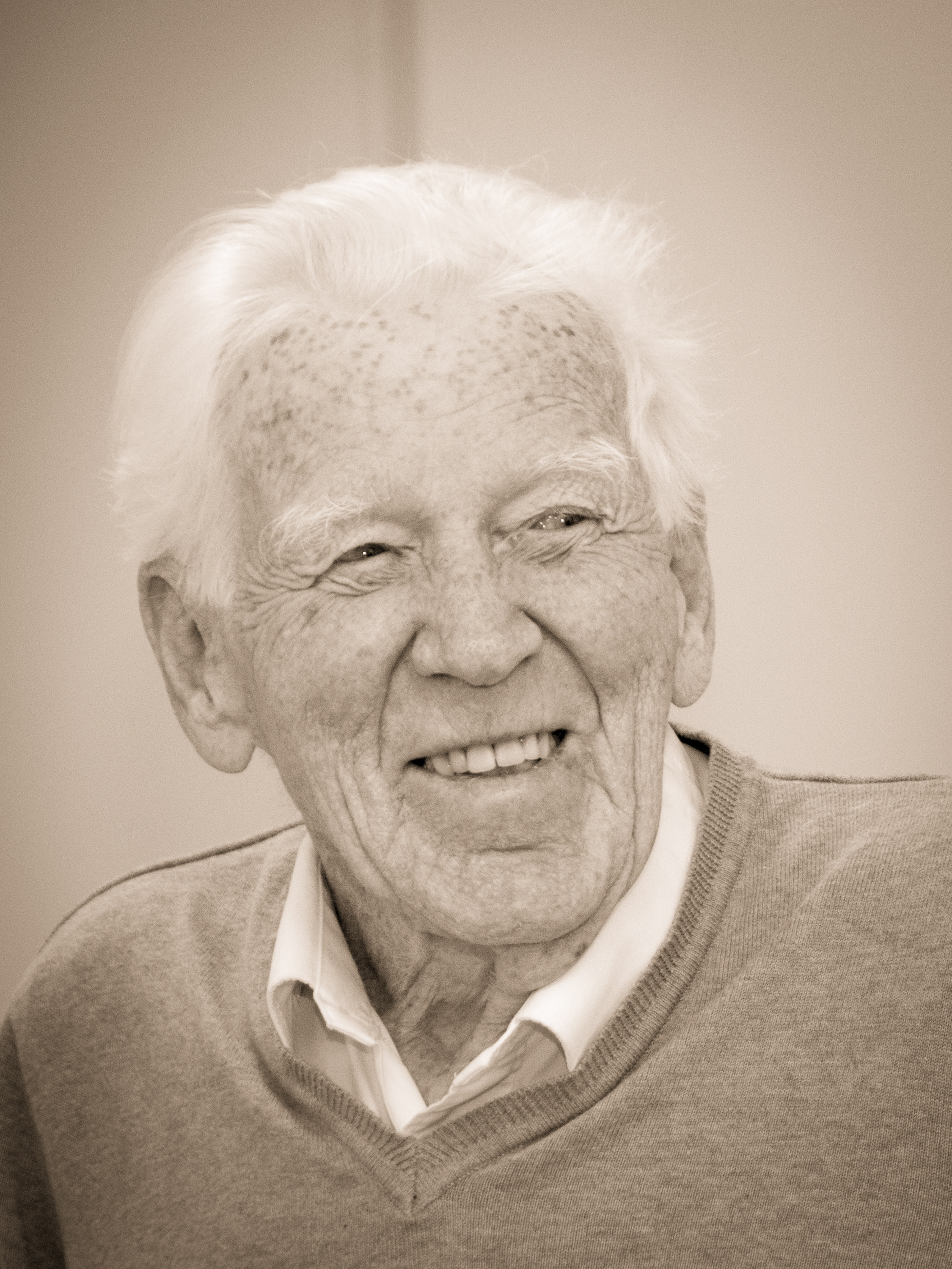 Svartvit porträttbild på en glad gammal man.