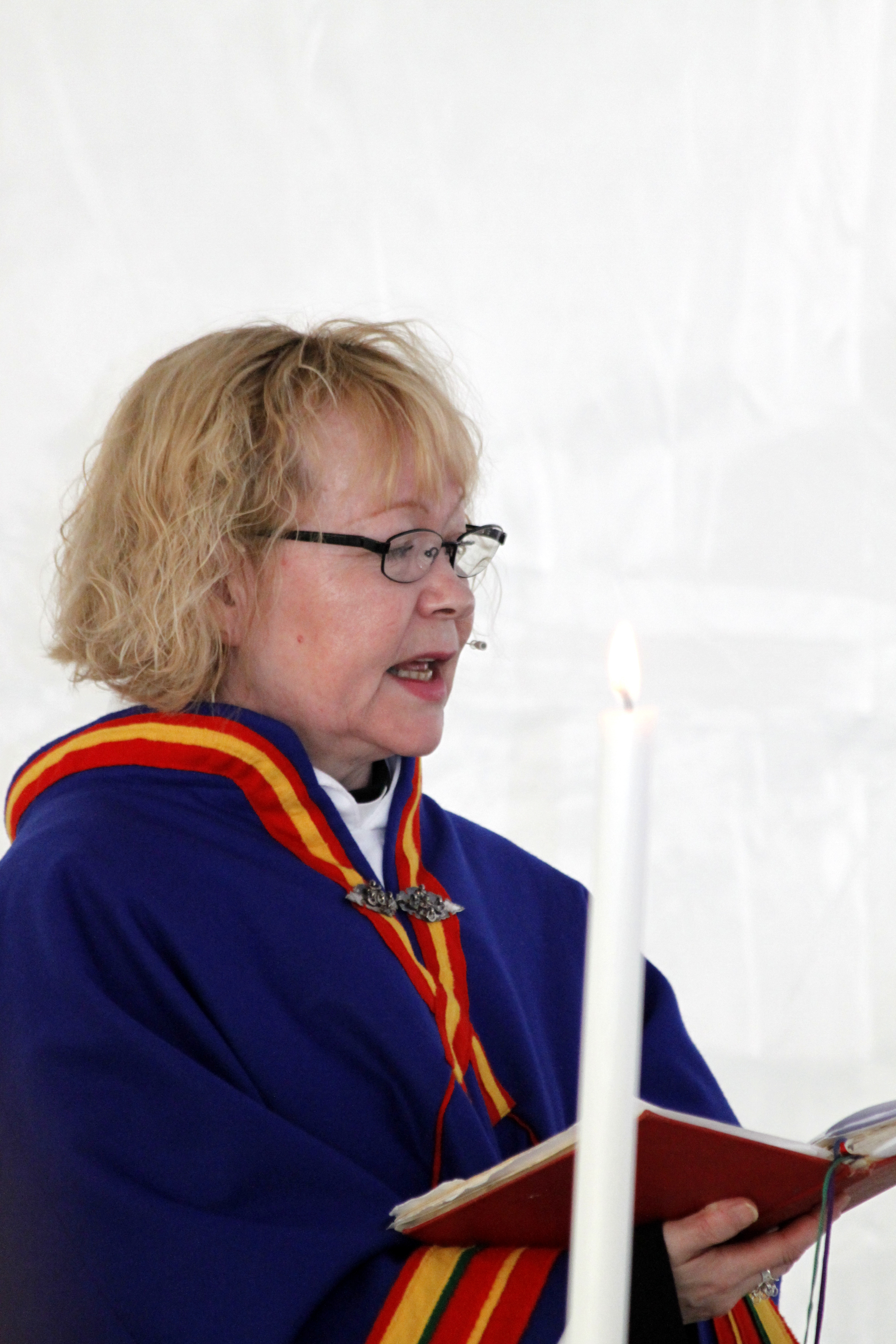 En kvinnlig samisk präst läser ur bibeln.