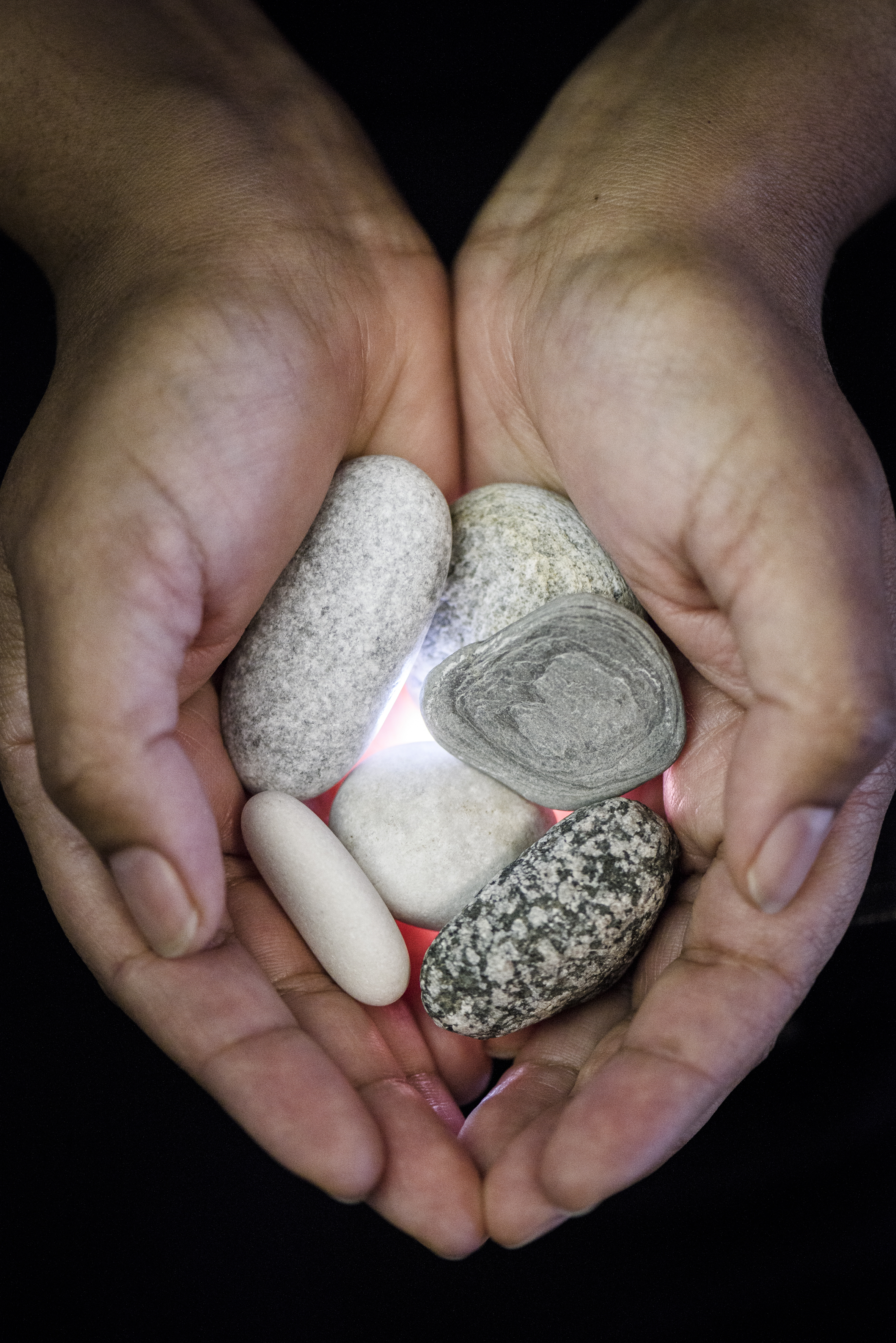 Närbild på en person som håller fram några stenar i handflatorna.