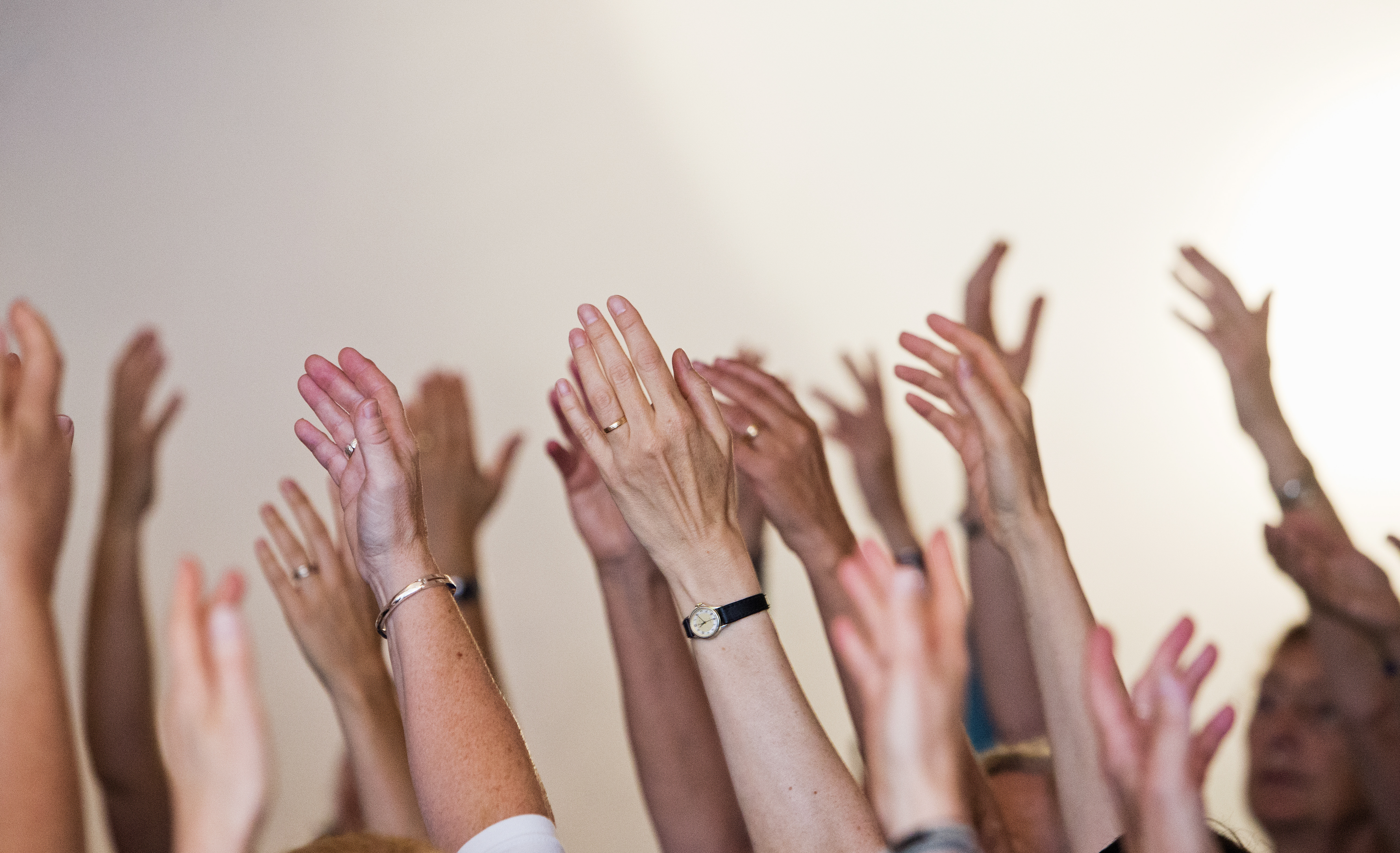 Flera armar uppsträckta mot taket.