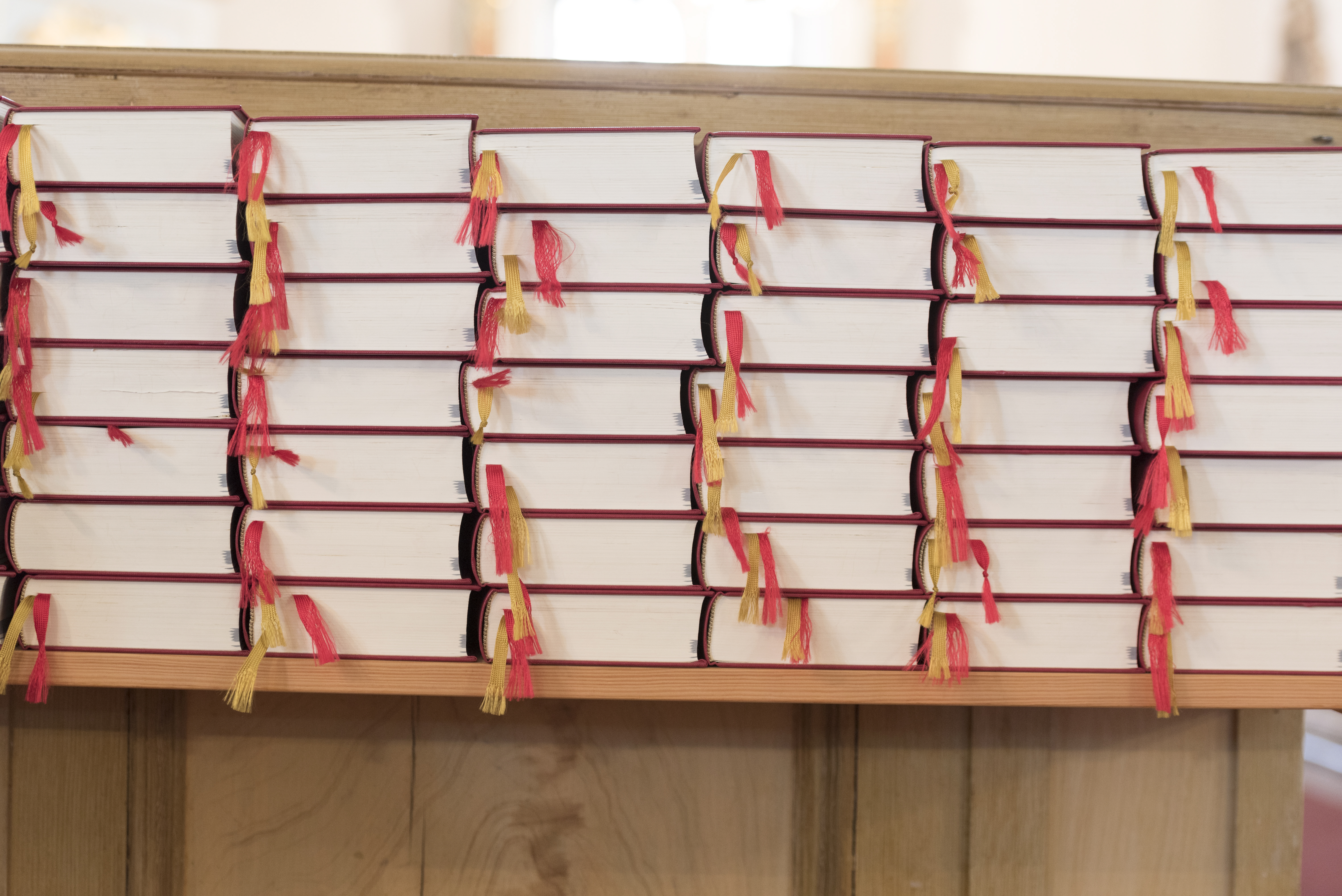 Rader med psalmböcker staplade på varandra i en hylla.