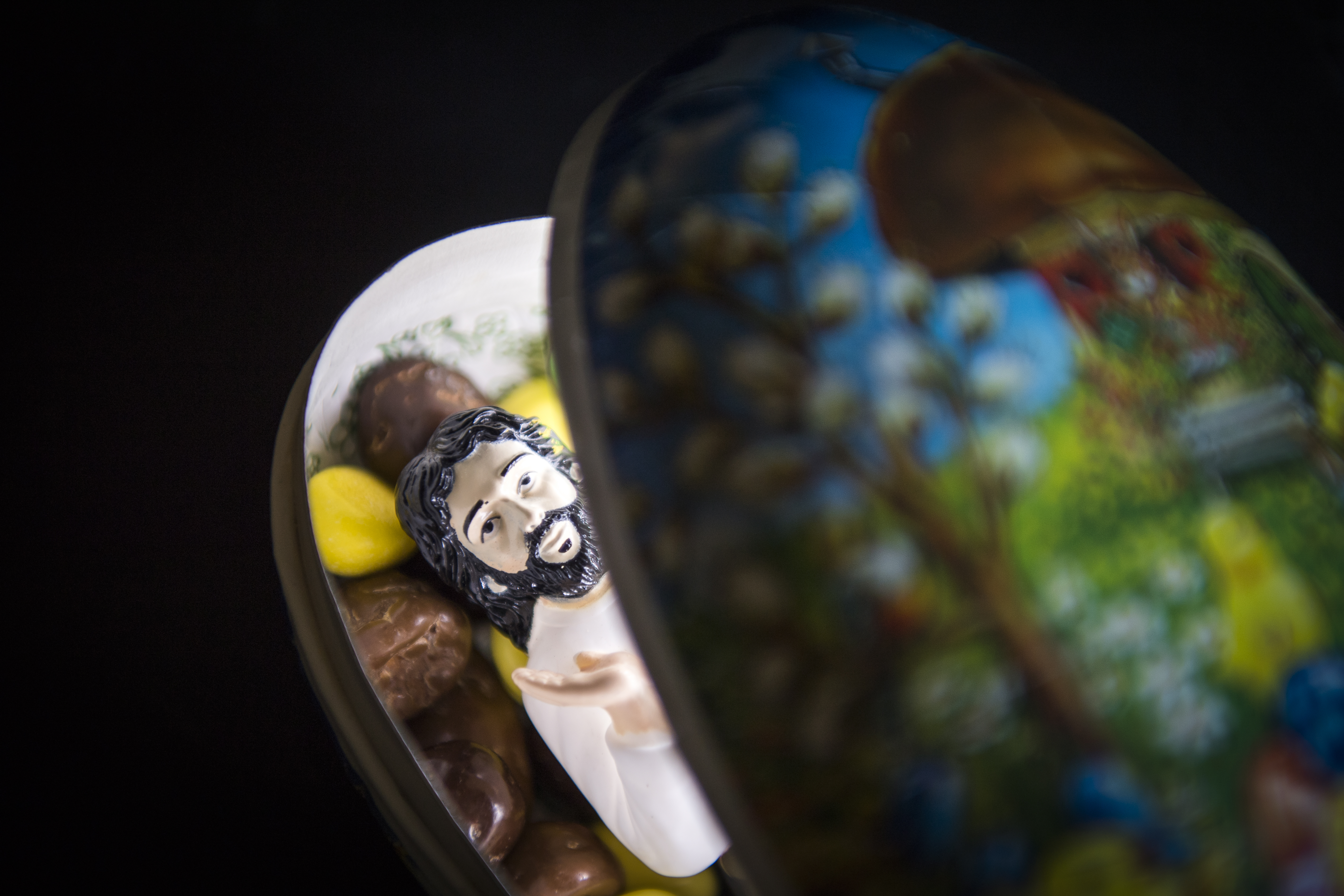 En figur av Jesus ligger bland godiset i ett påskägg.