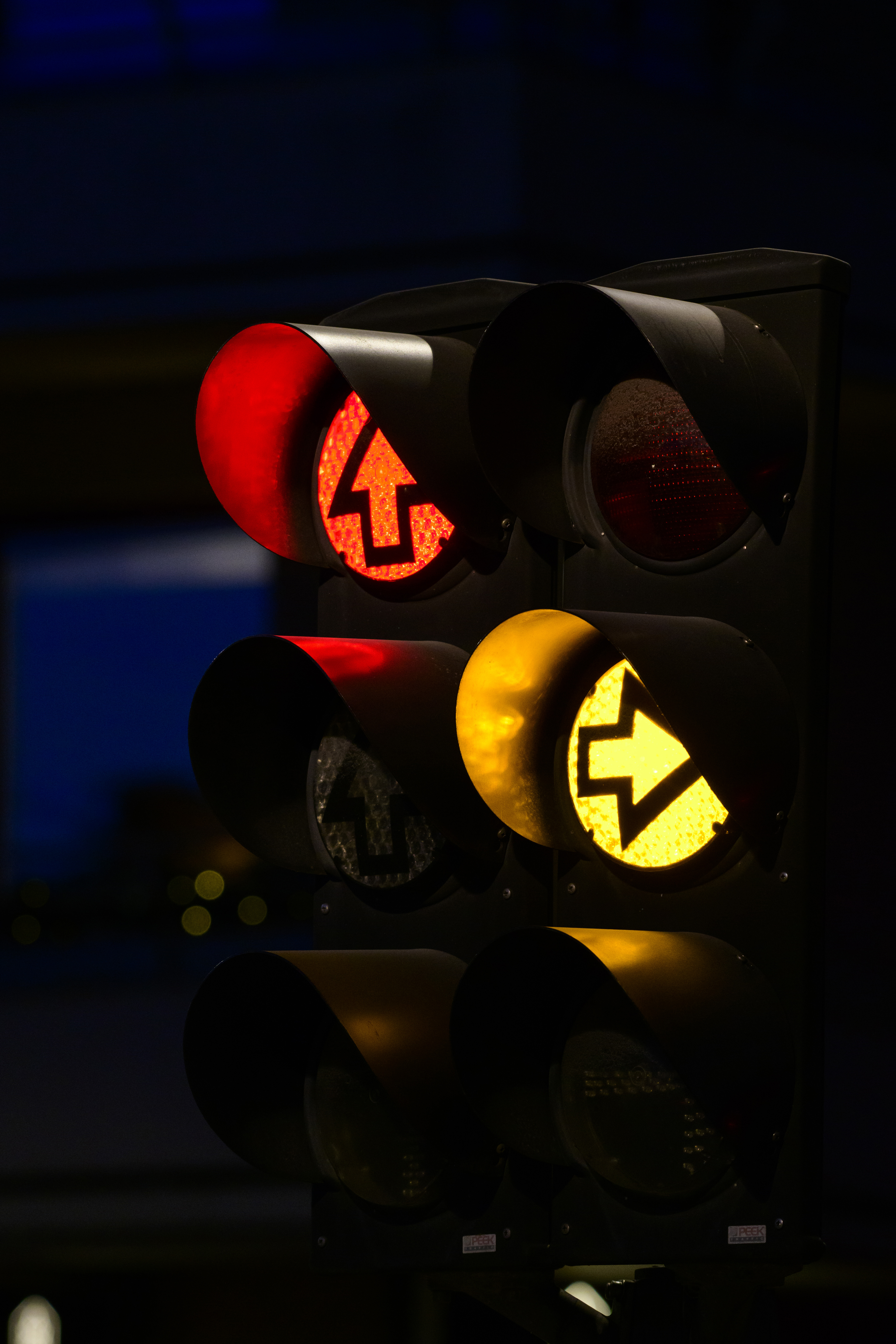 Ett trafikljus lyser rött och gult i mörkret.
