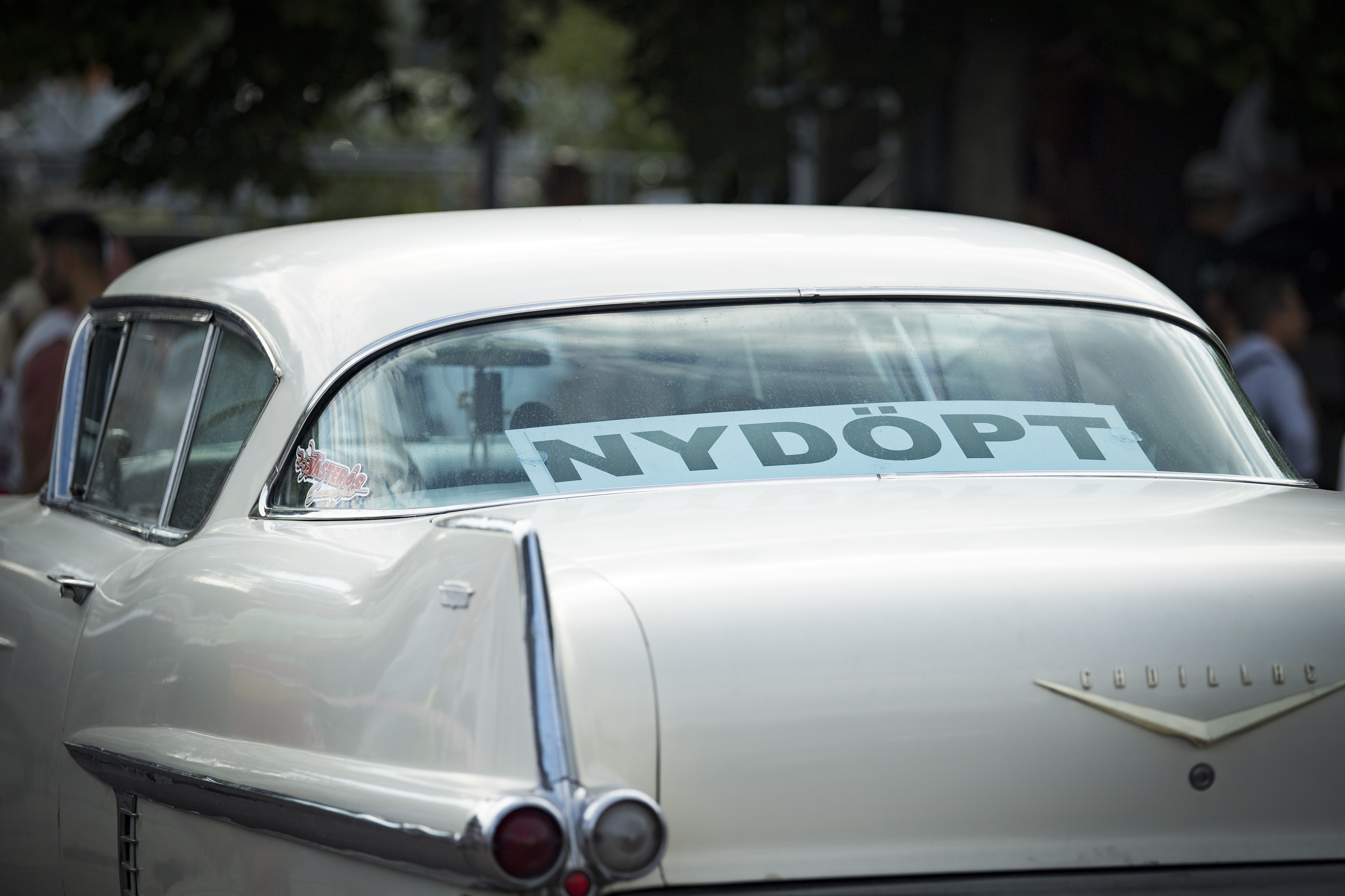 En skylt i bakrutan av en bil med texten Nydöpt.