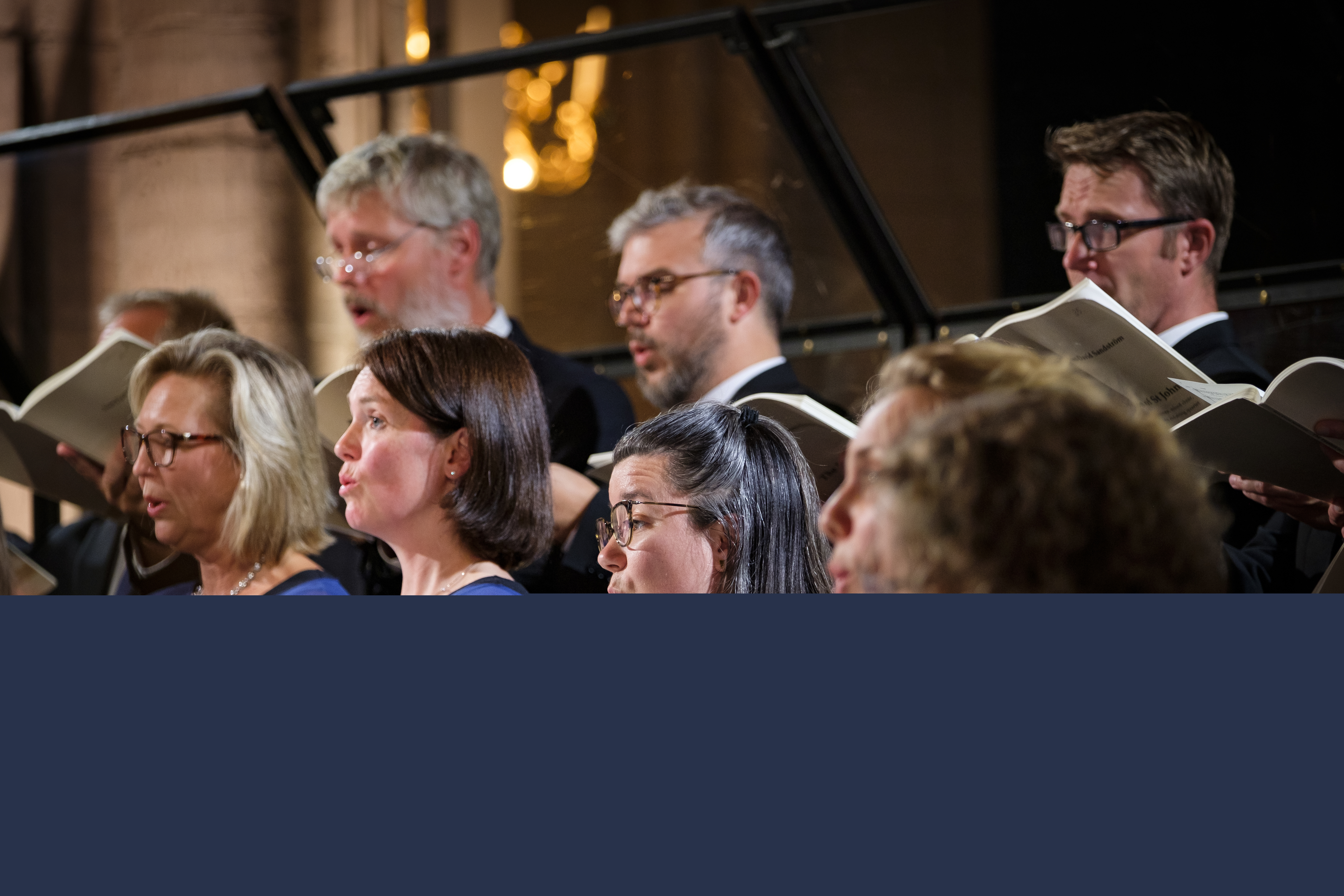 En blandad kyrkokör i matchande blå färger sjunger i Uppsala domkyrka.