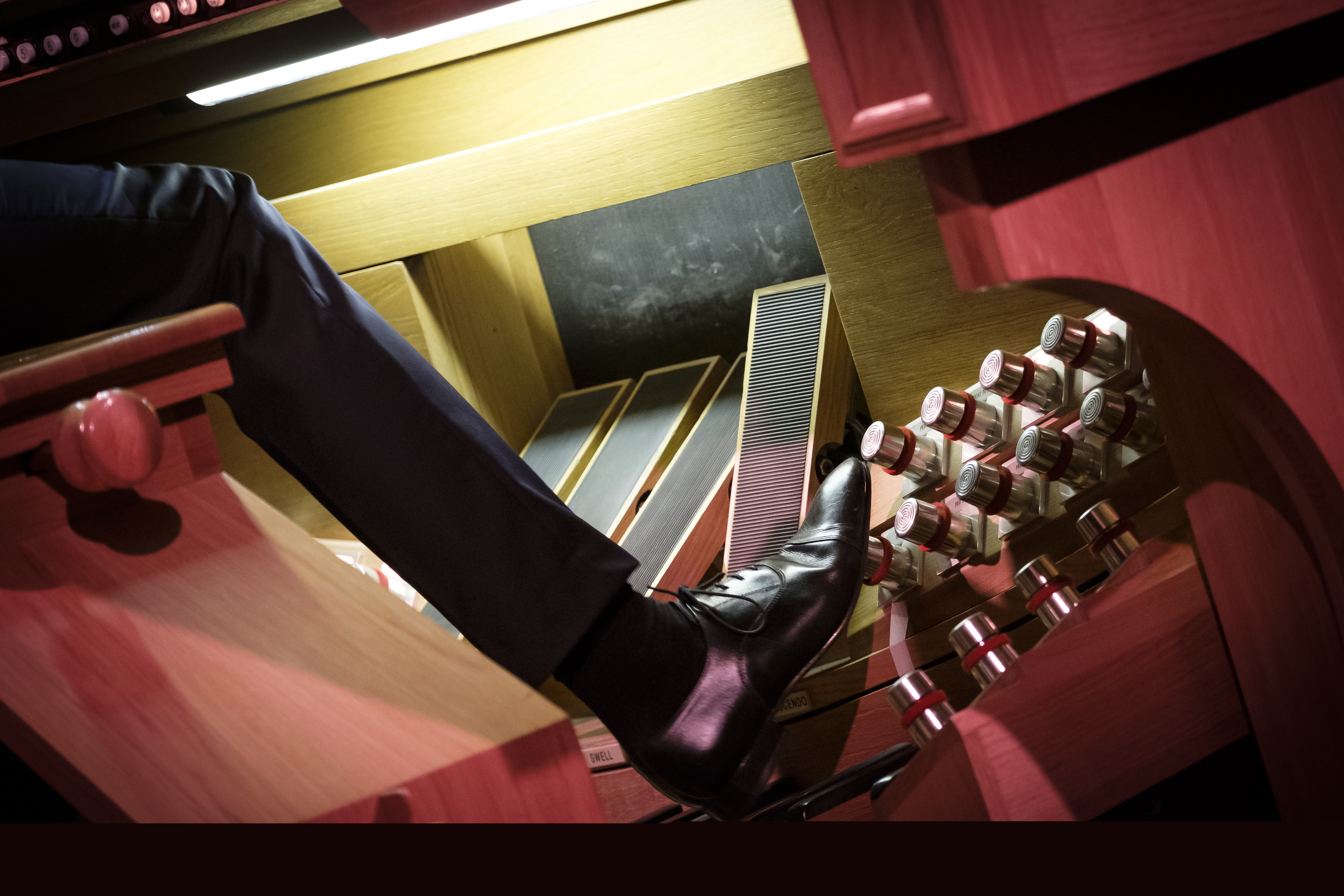 En kyrkoorganist använder orgelns fotpedaler.