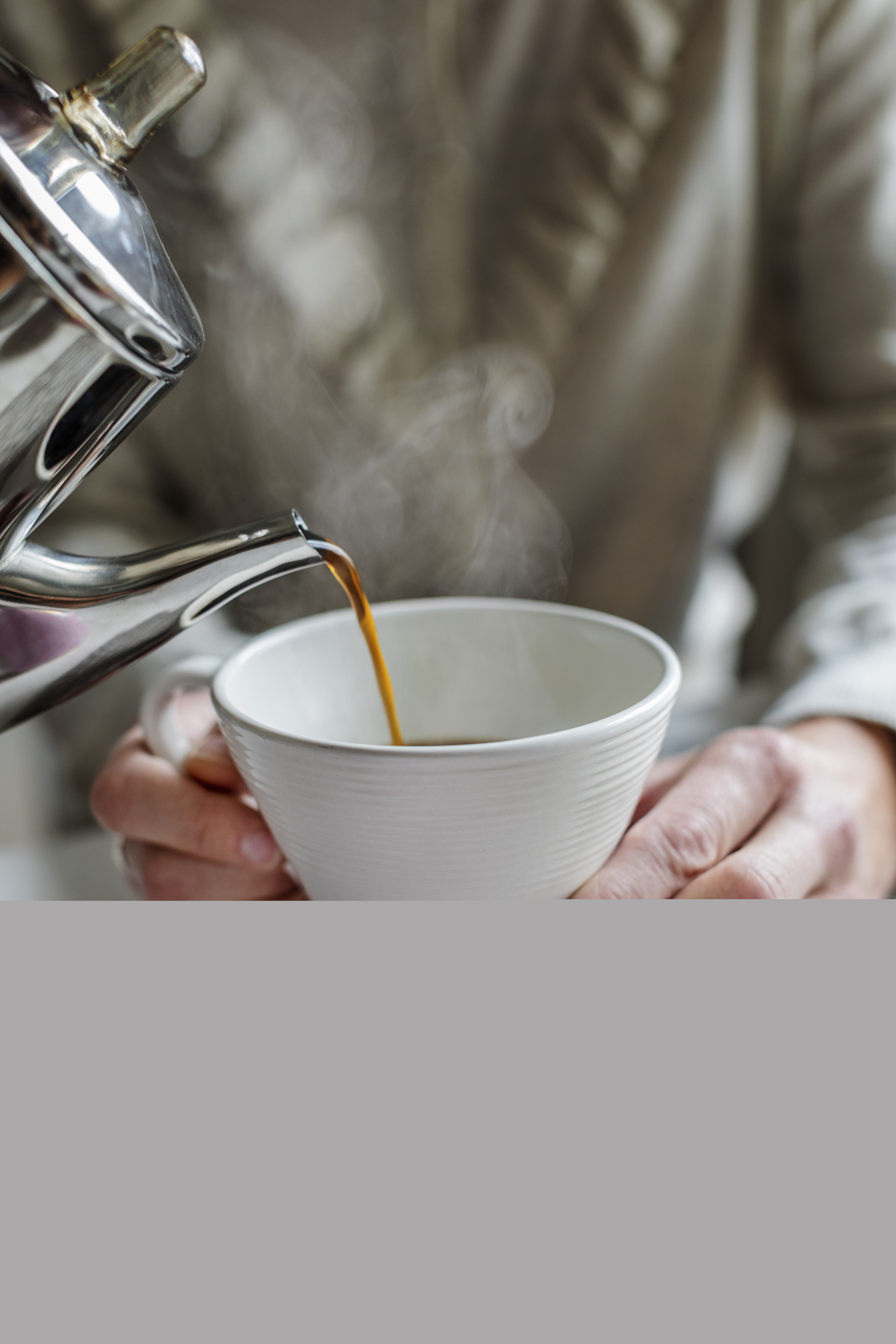 En person häller upp kaffe till någon som håller upp sin kopp.