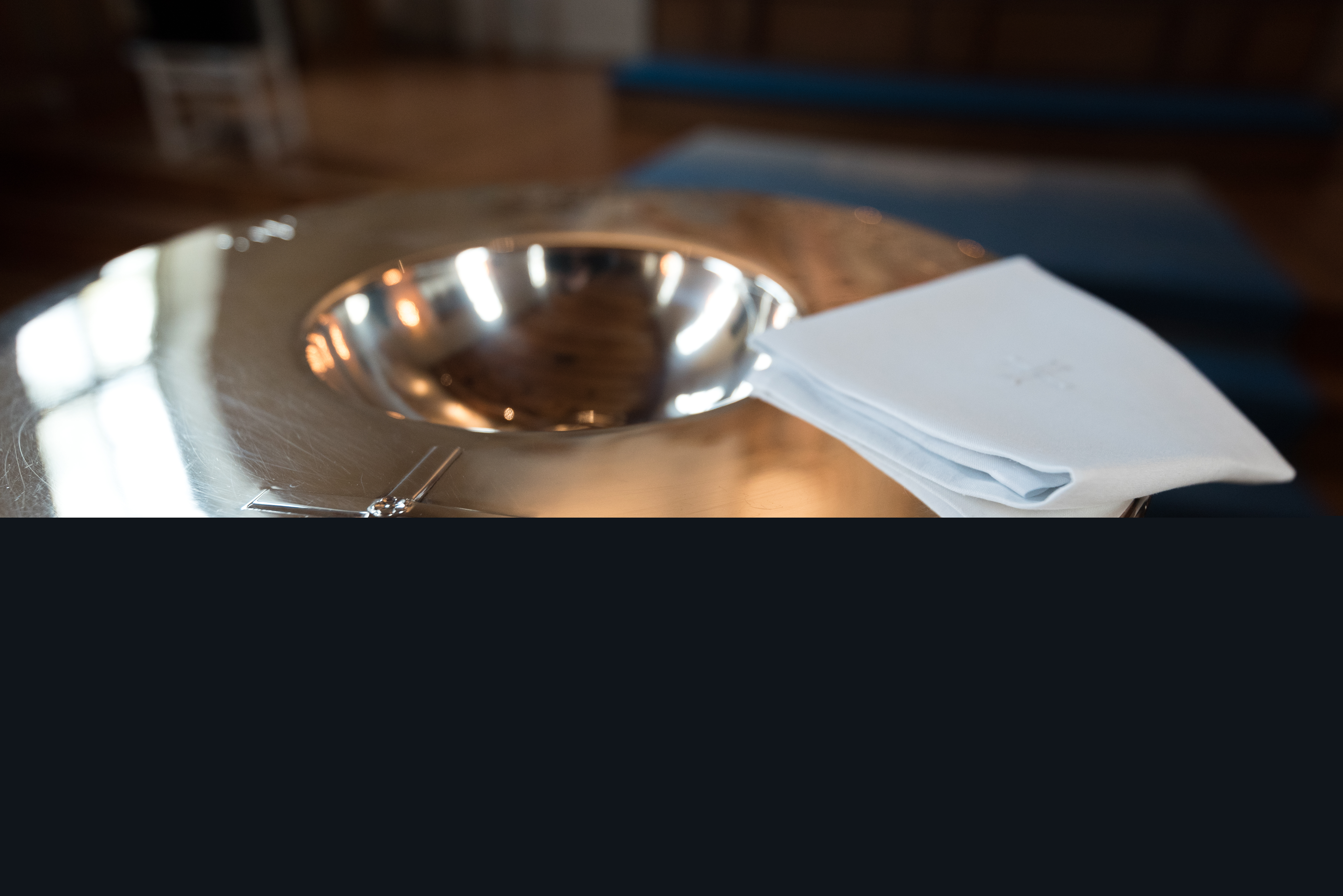 En vit liten duk ligger på en dopfunt.