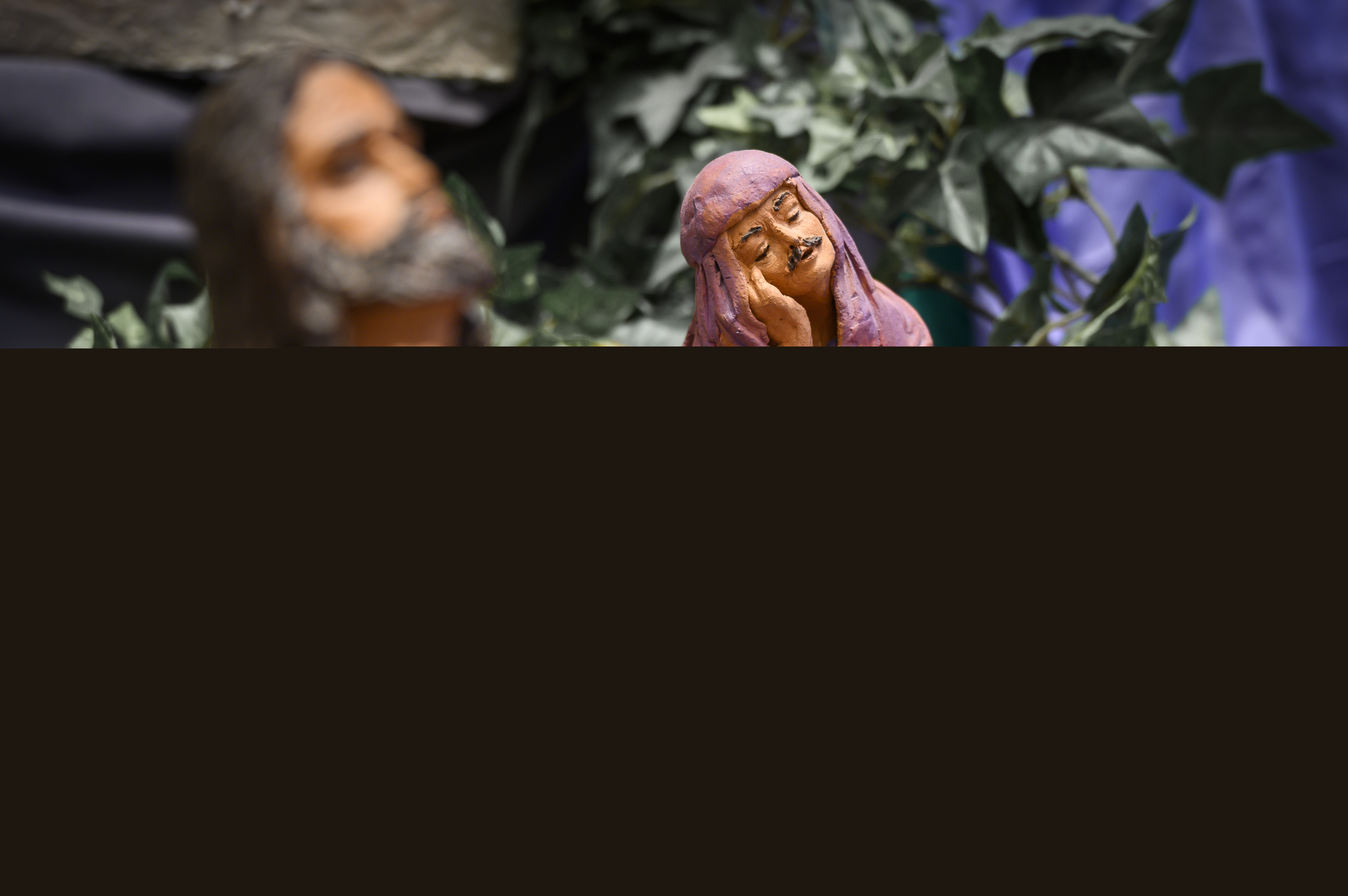 Modell med Jesus och två män i ljusröda kåpor och huvuddukar.