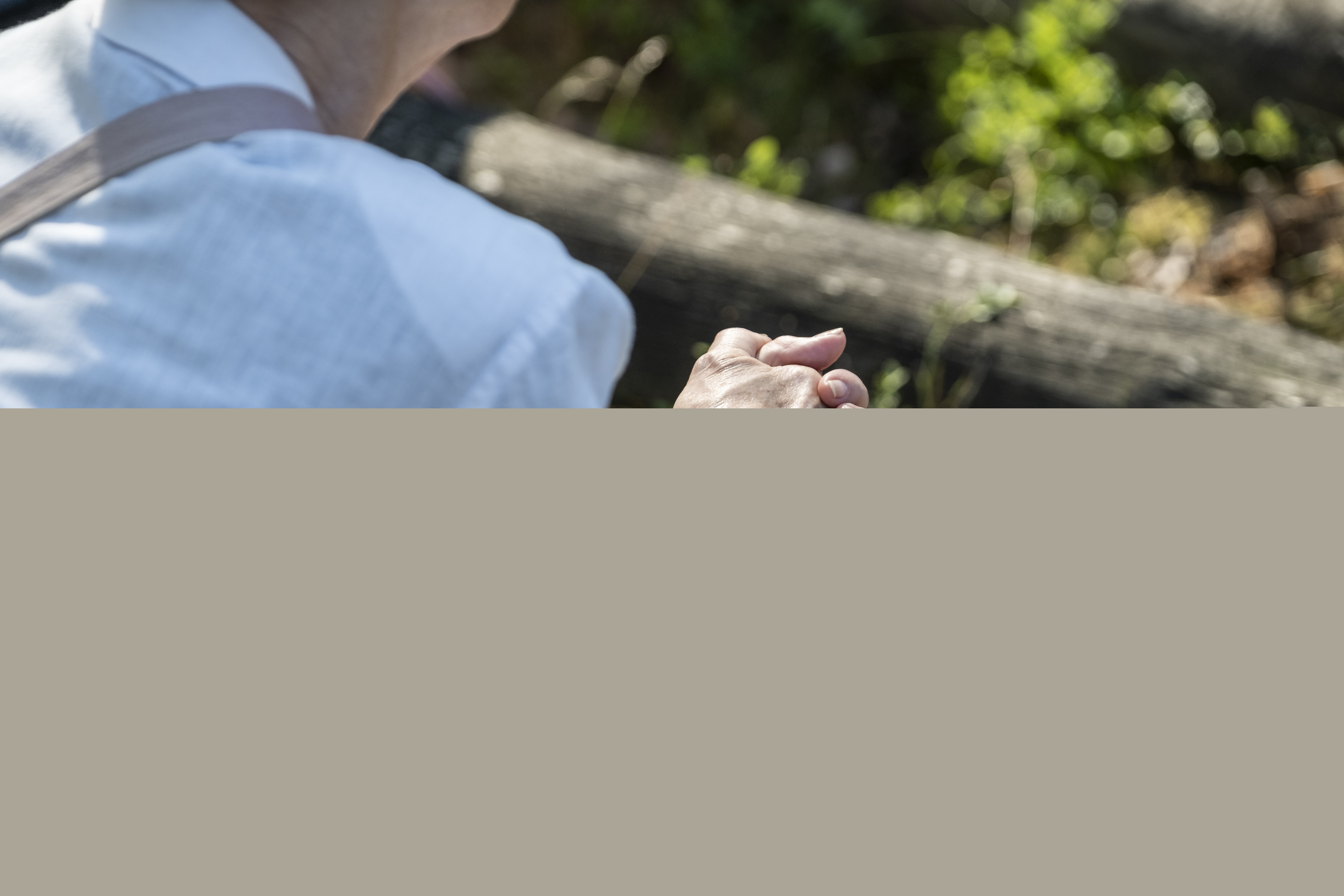 En person i skjorta sitter i skogen.