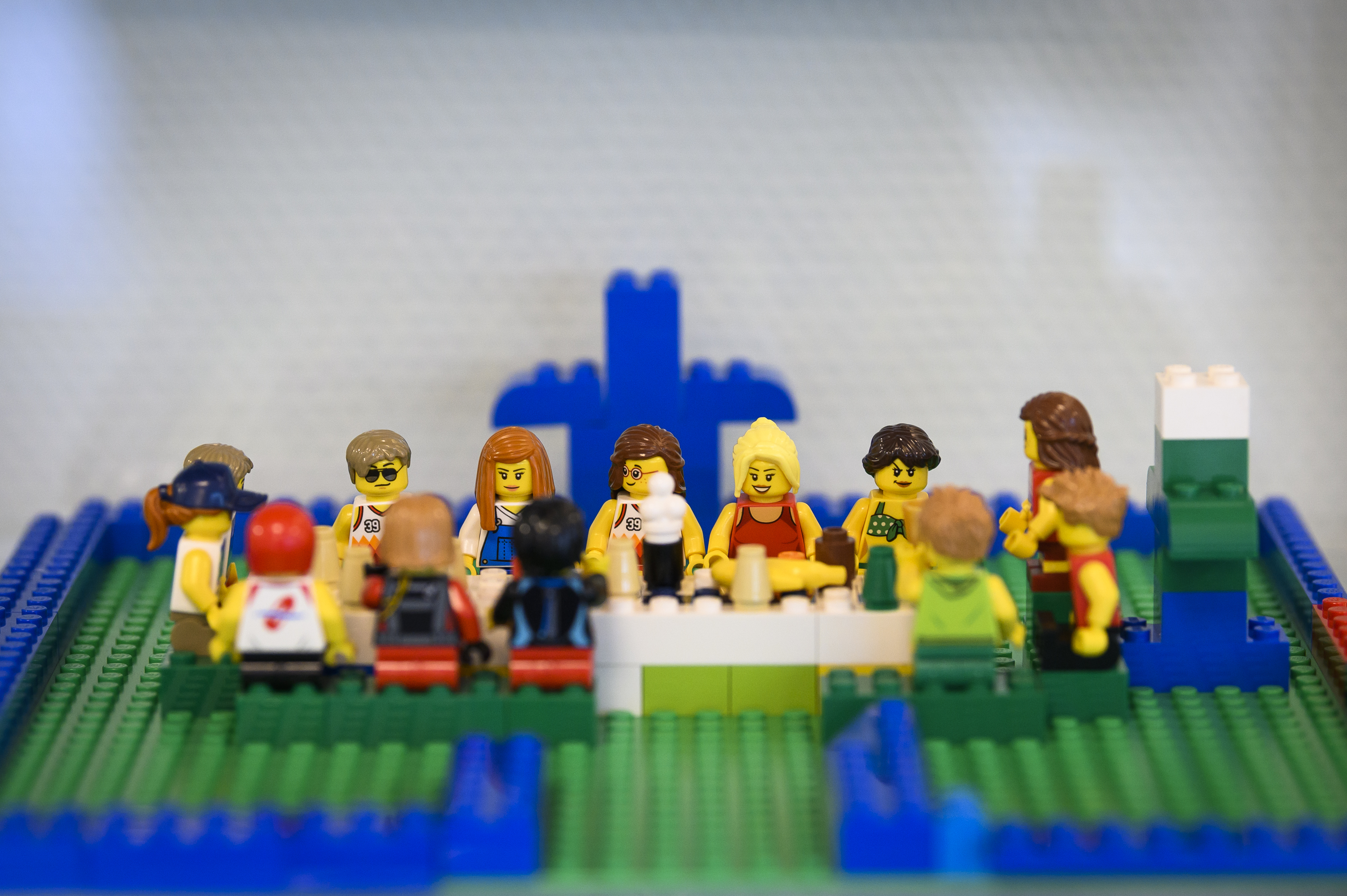 Någon har byggt med Lego: en grupp personer med olika utseenden sitter runt ett långbord.