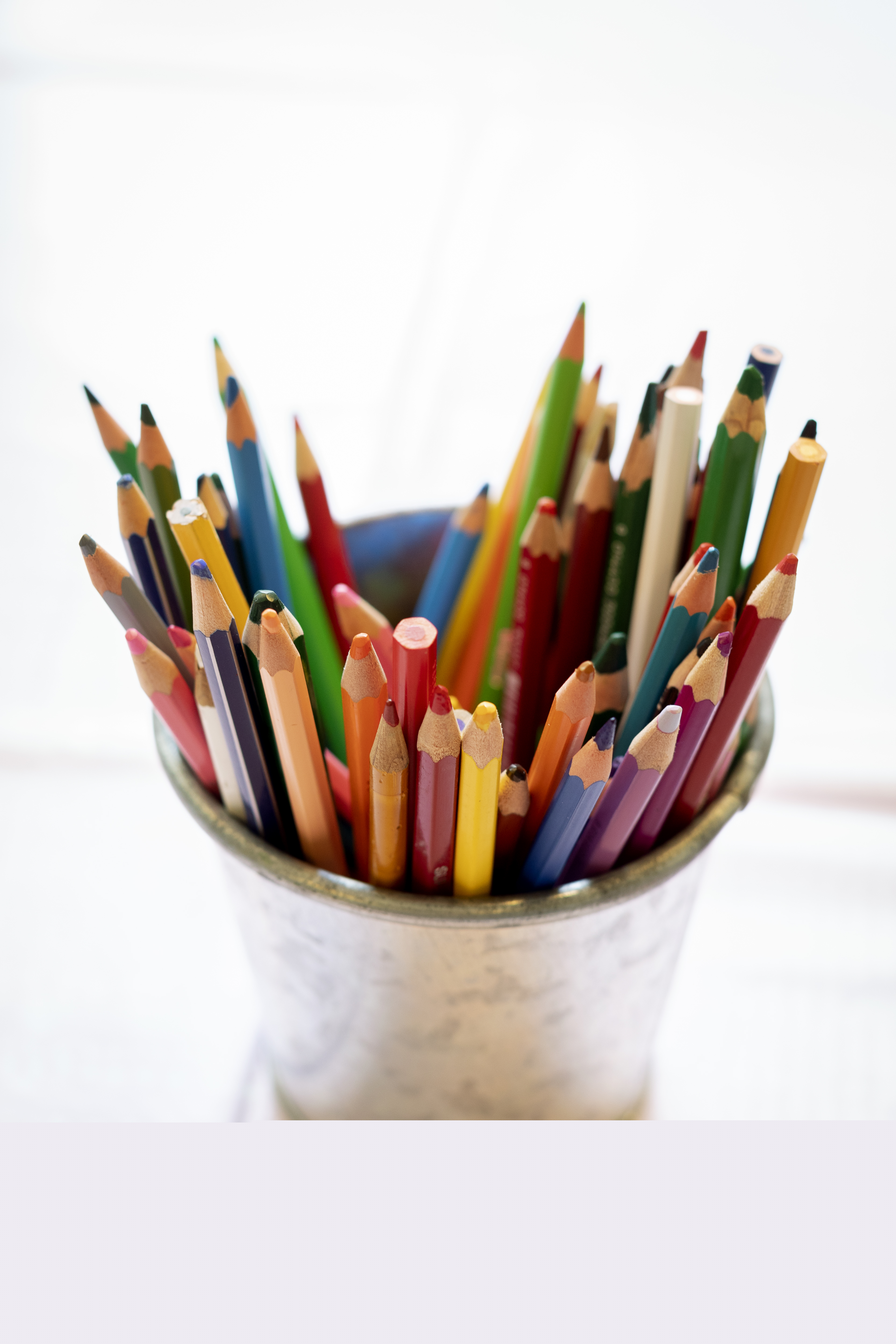 En metallburk med färggranna pennor.