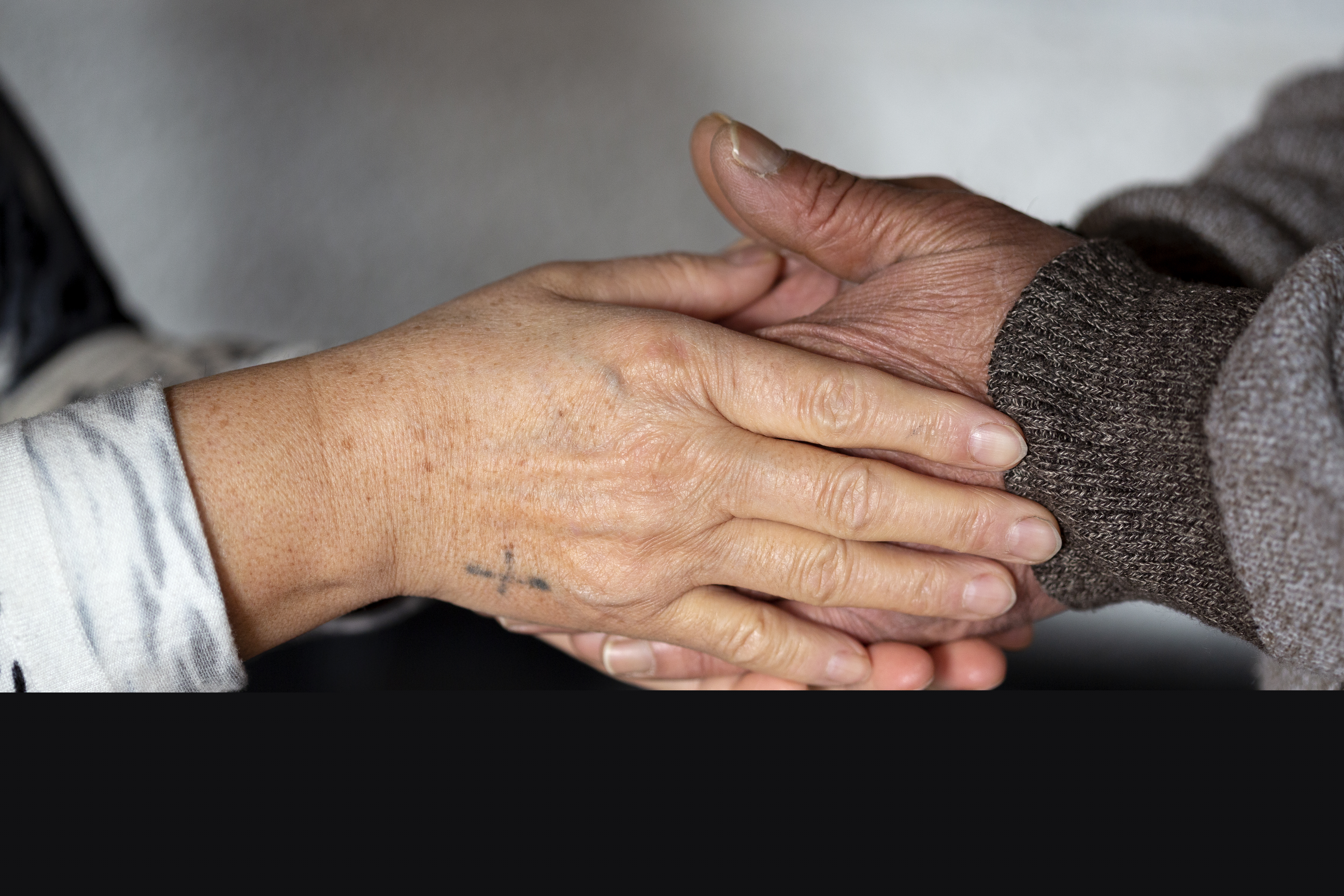 Två personer håller om varandras händer.