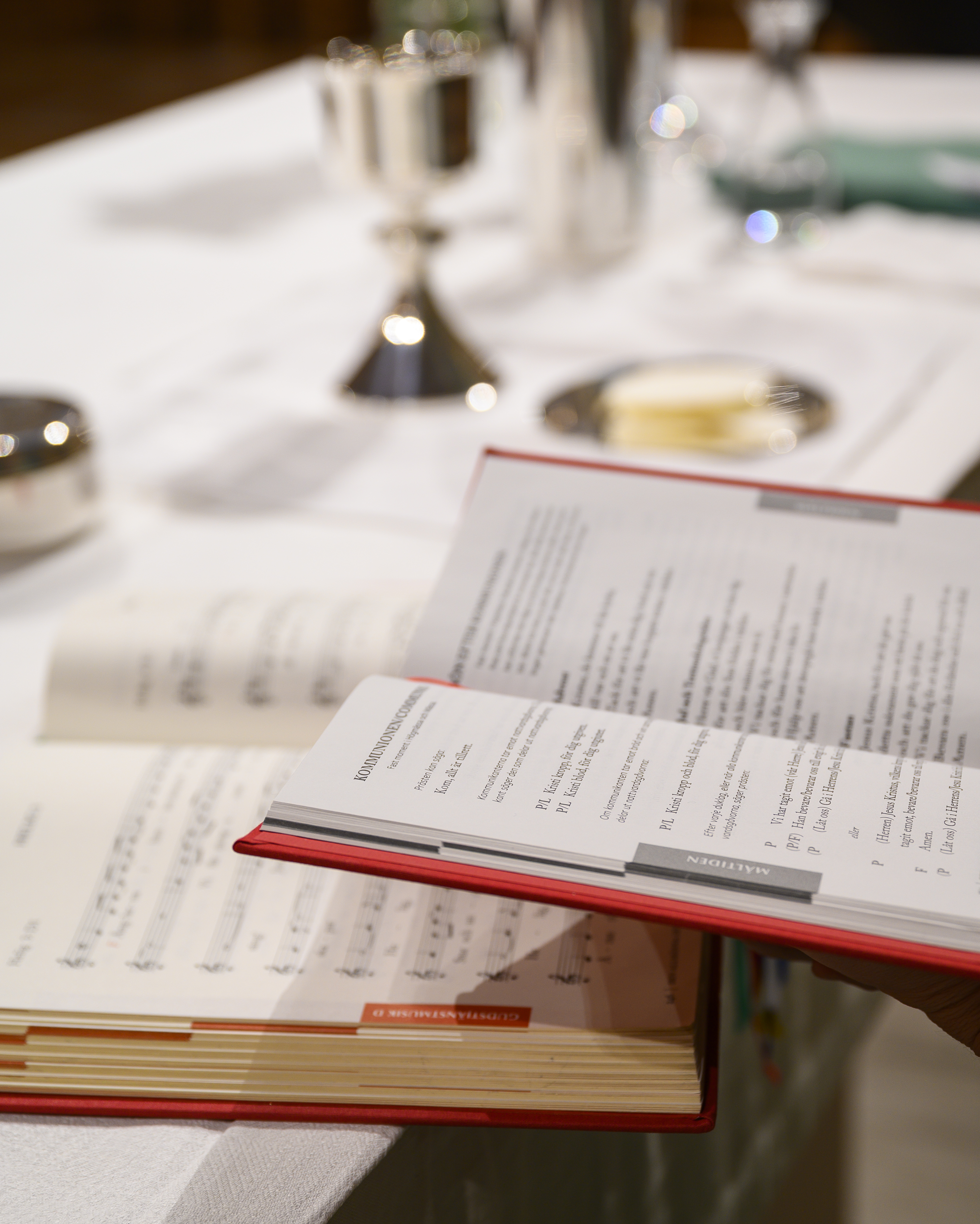 En psalmbok och en bönbok ligger uppslagna på nattvardsbordet.