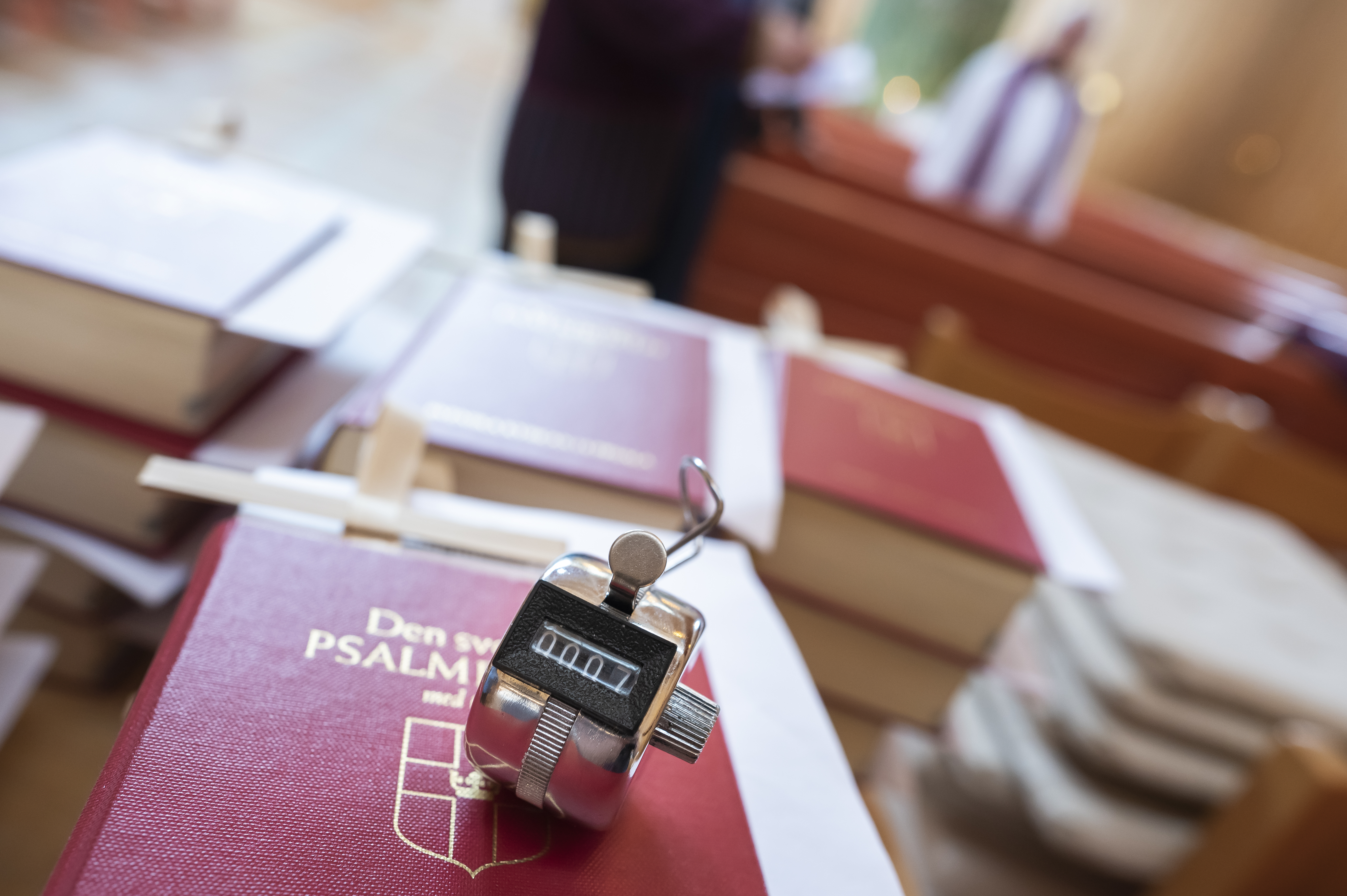 En handräknare ligger på en hög av psalmböcker.