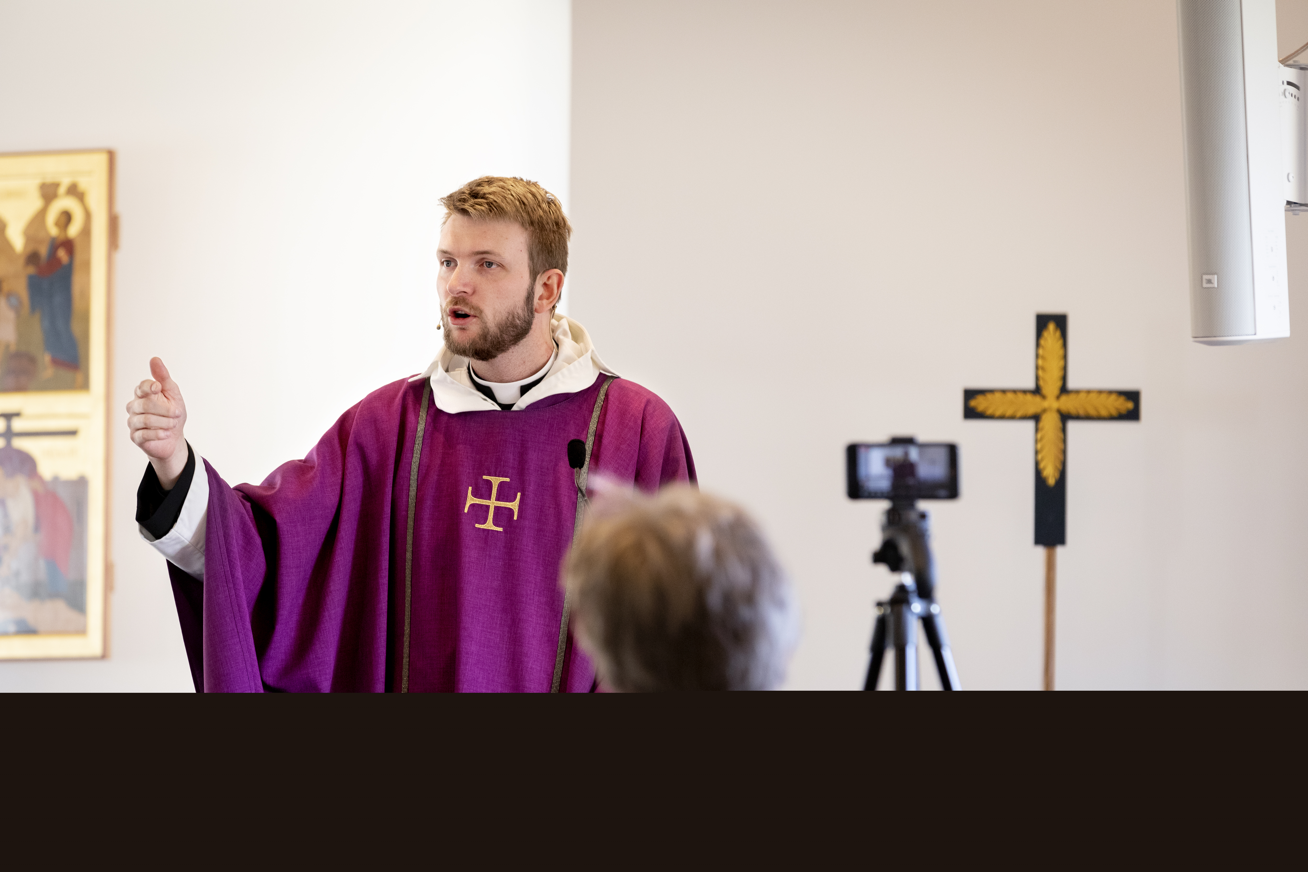 En präst predikar framför en kamera som filmar för direktsändning på webben.