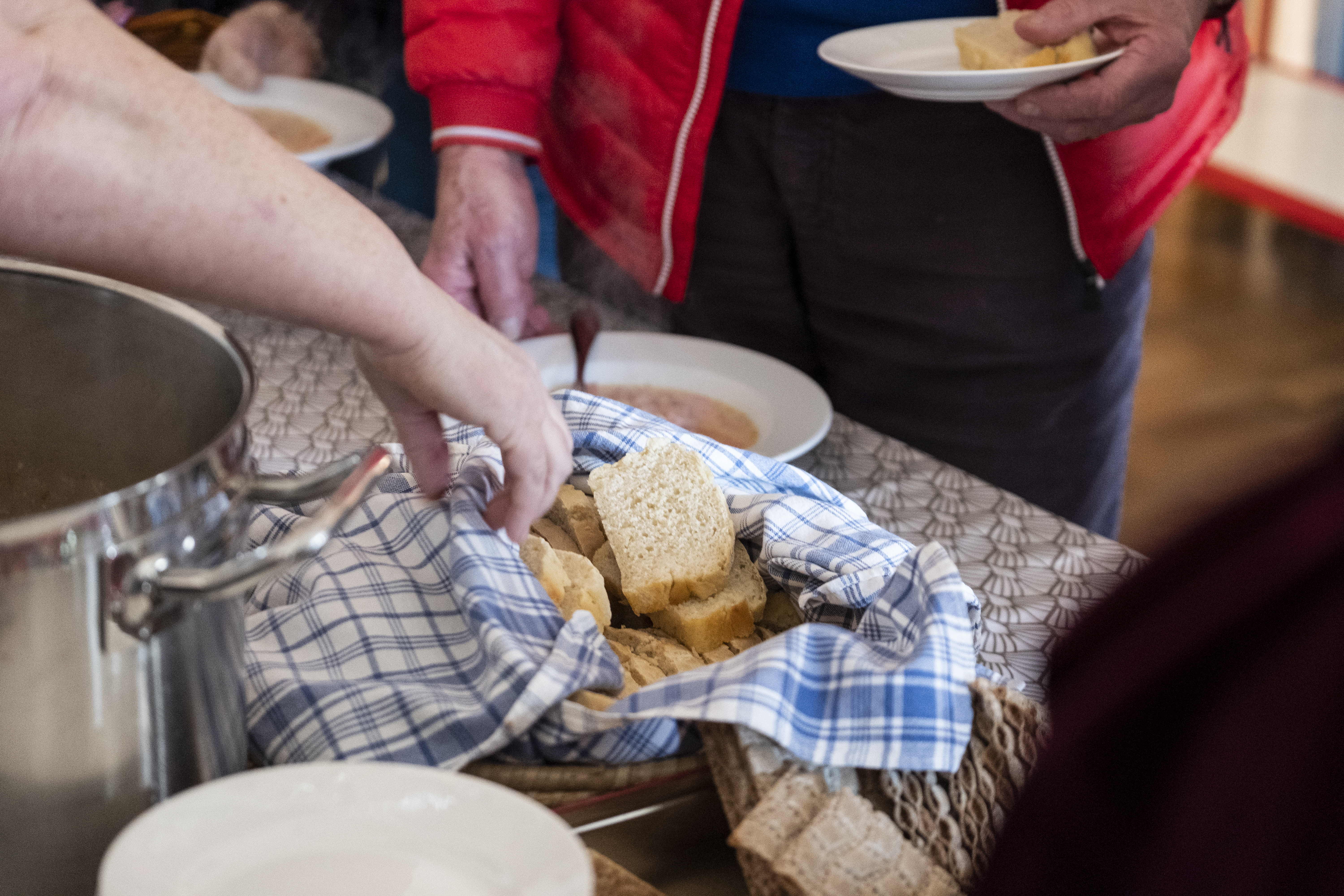 Någon tar en brödskiva ur den framställda korgen.