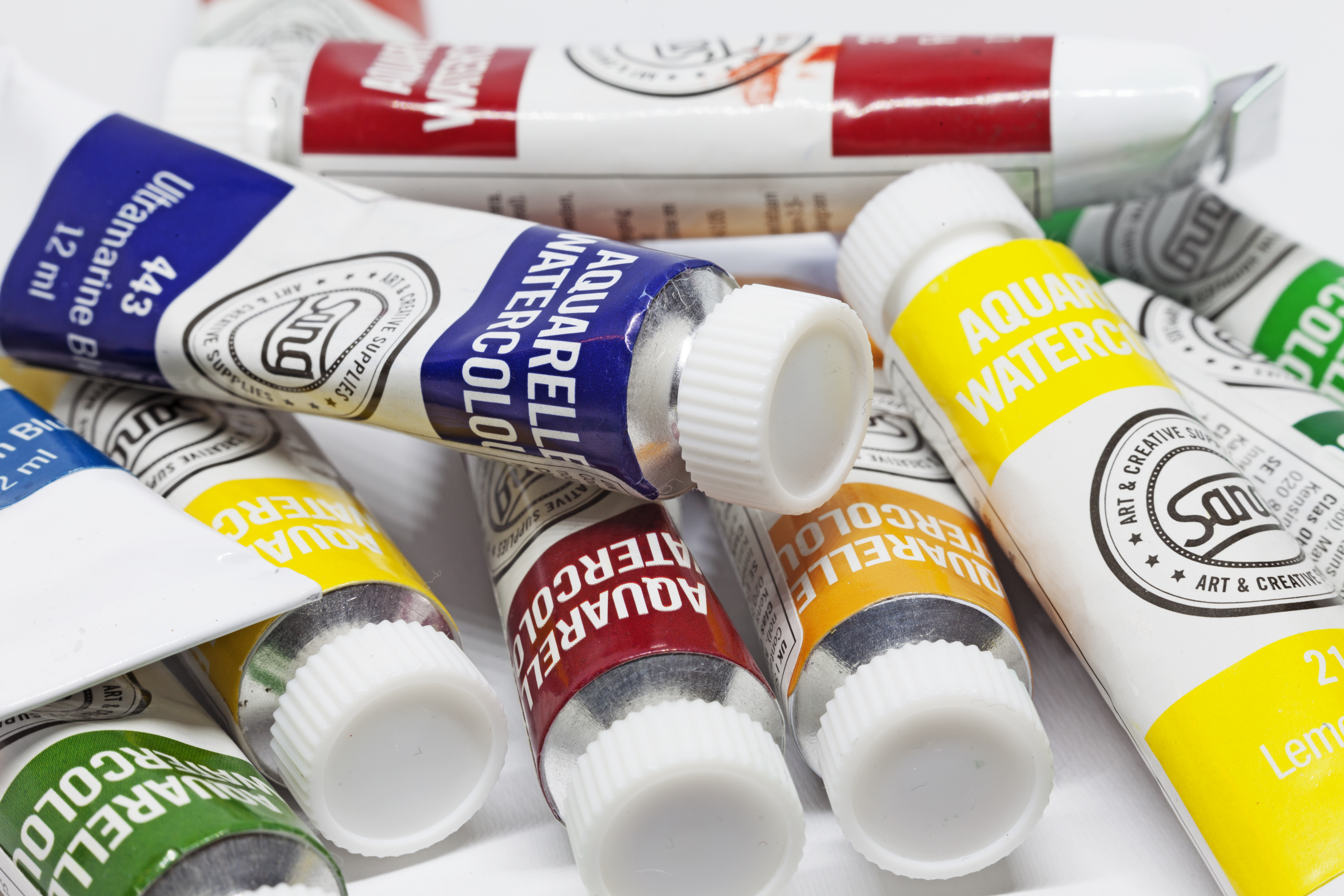 Närbild på en hög tuber med akvarellfärg i olika nyanser.