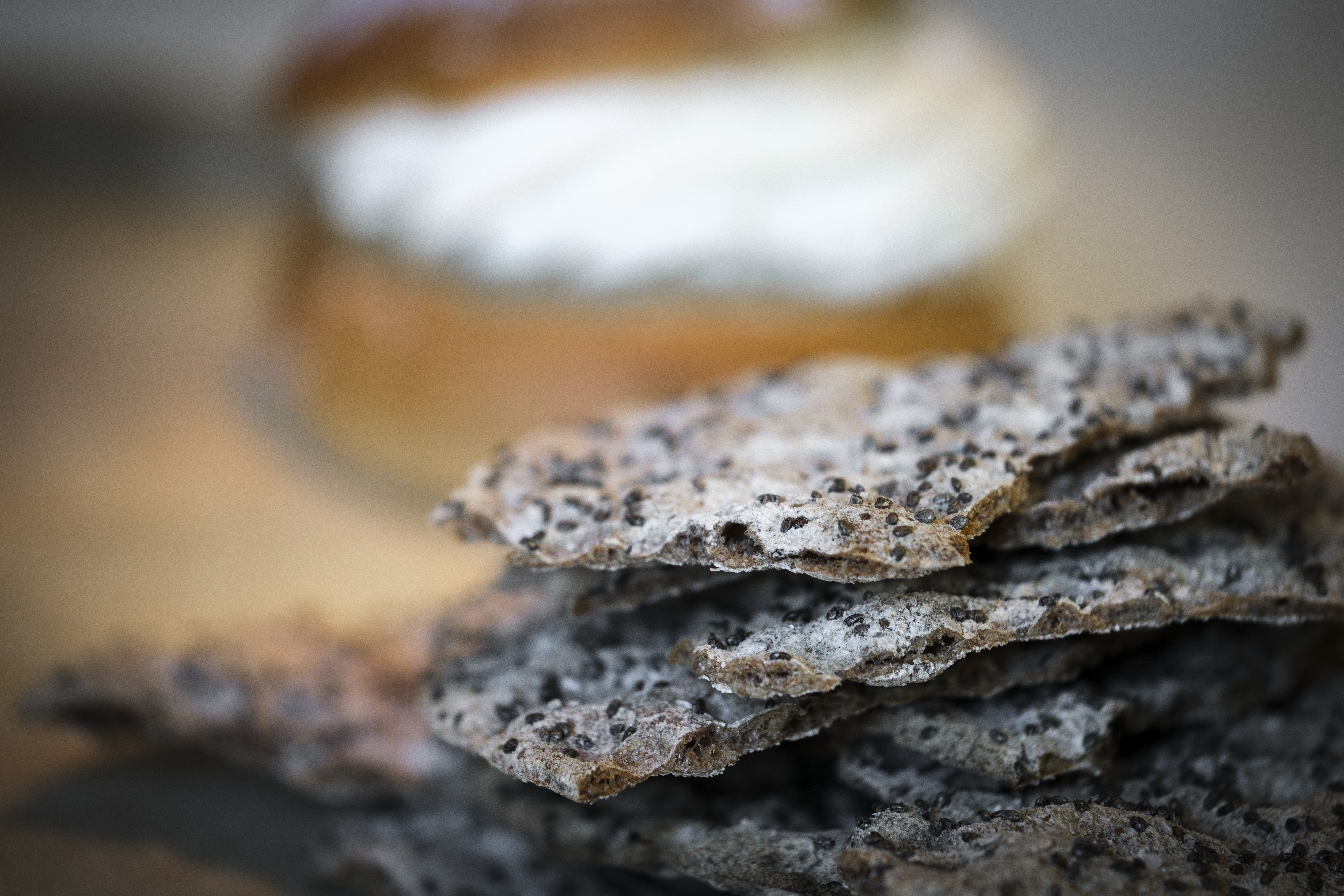 En hög med knäckebröd. I bakgrunden anas en semla.