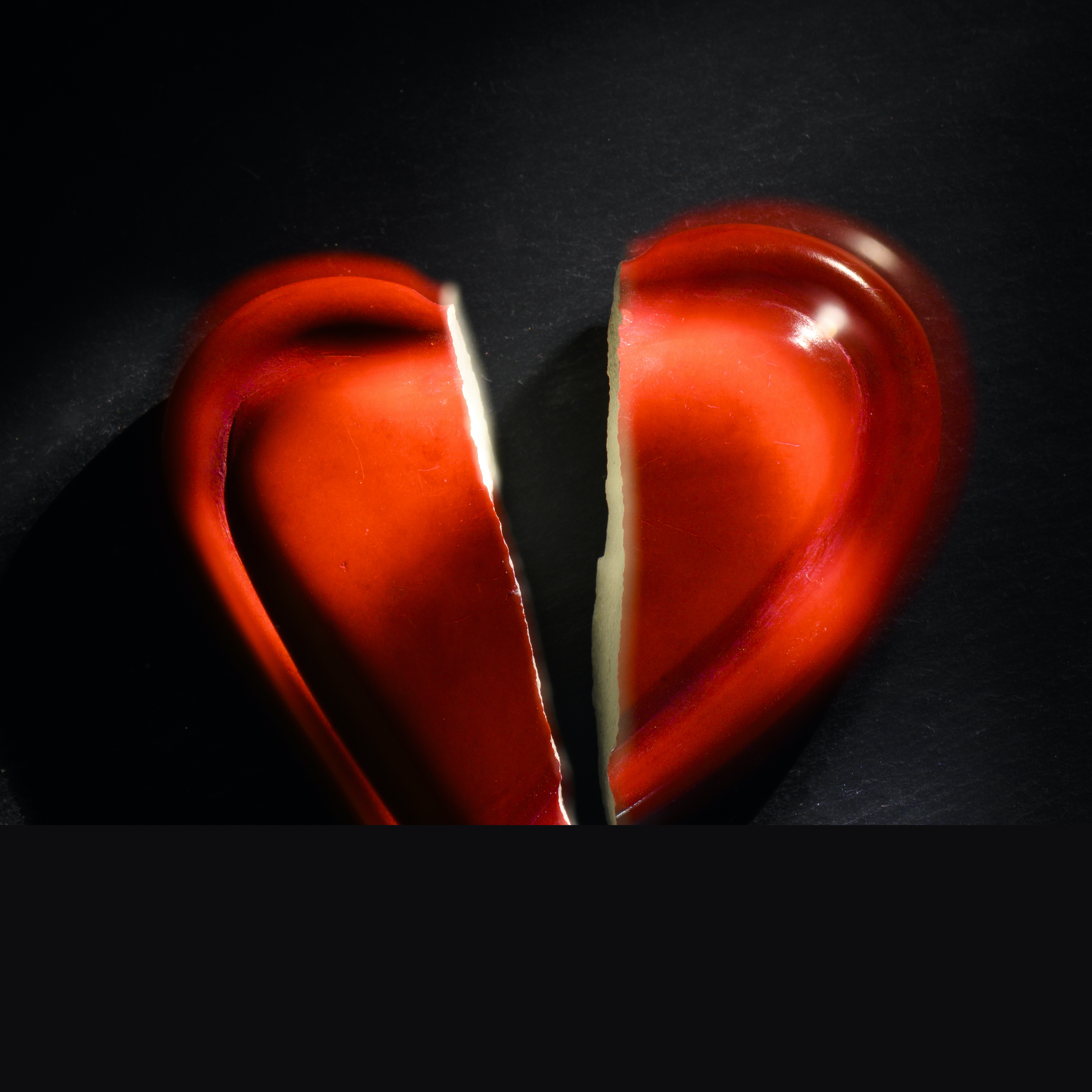 Rött keramikhjärta som spruckit mitt itu.