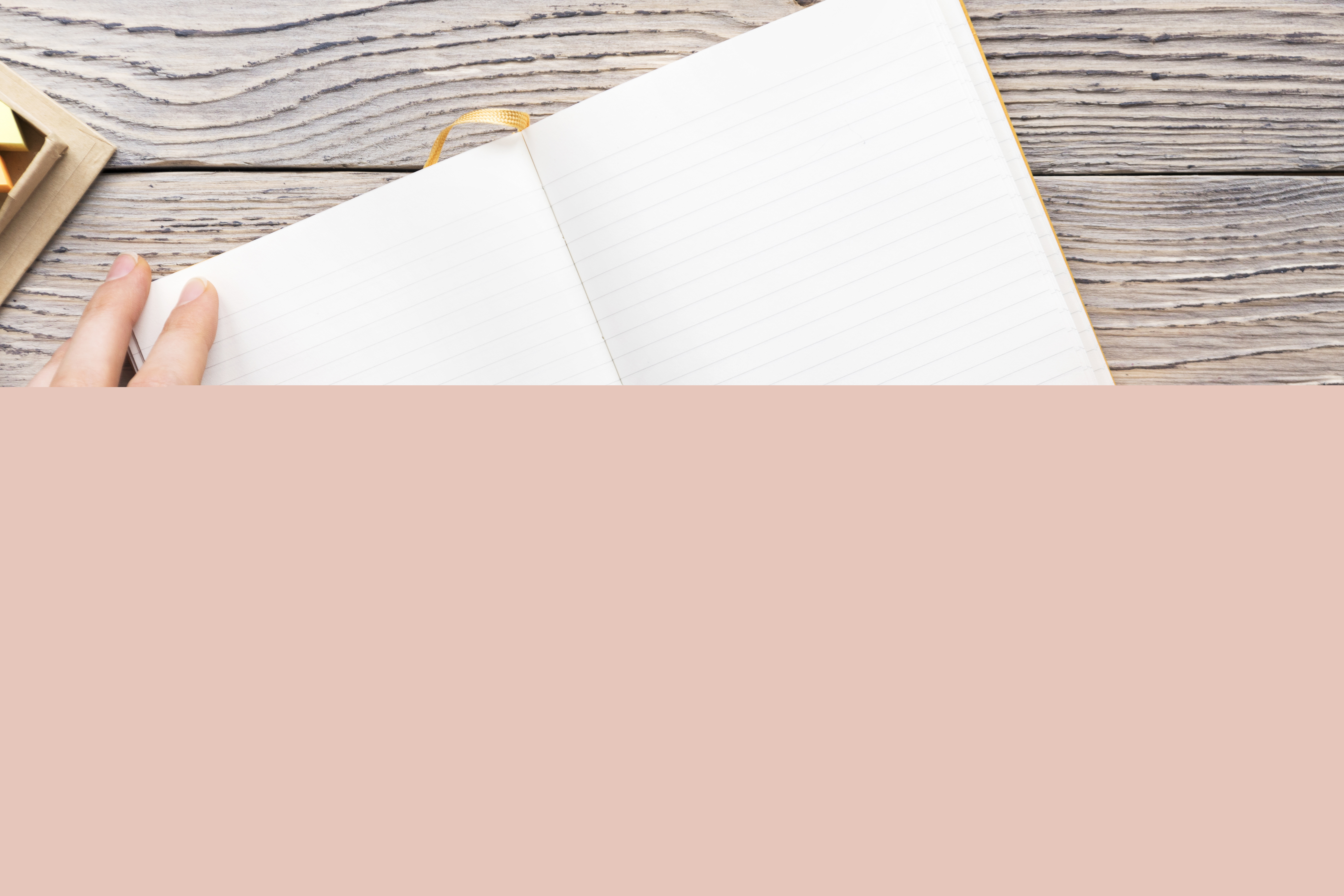 Någon skriver i ett tomt anteckningsblock med en blå penna.