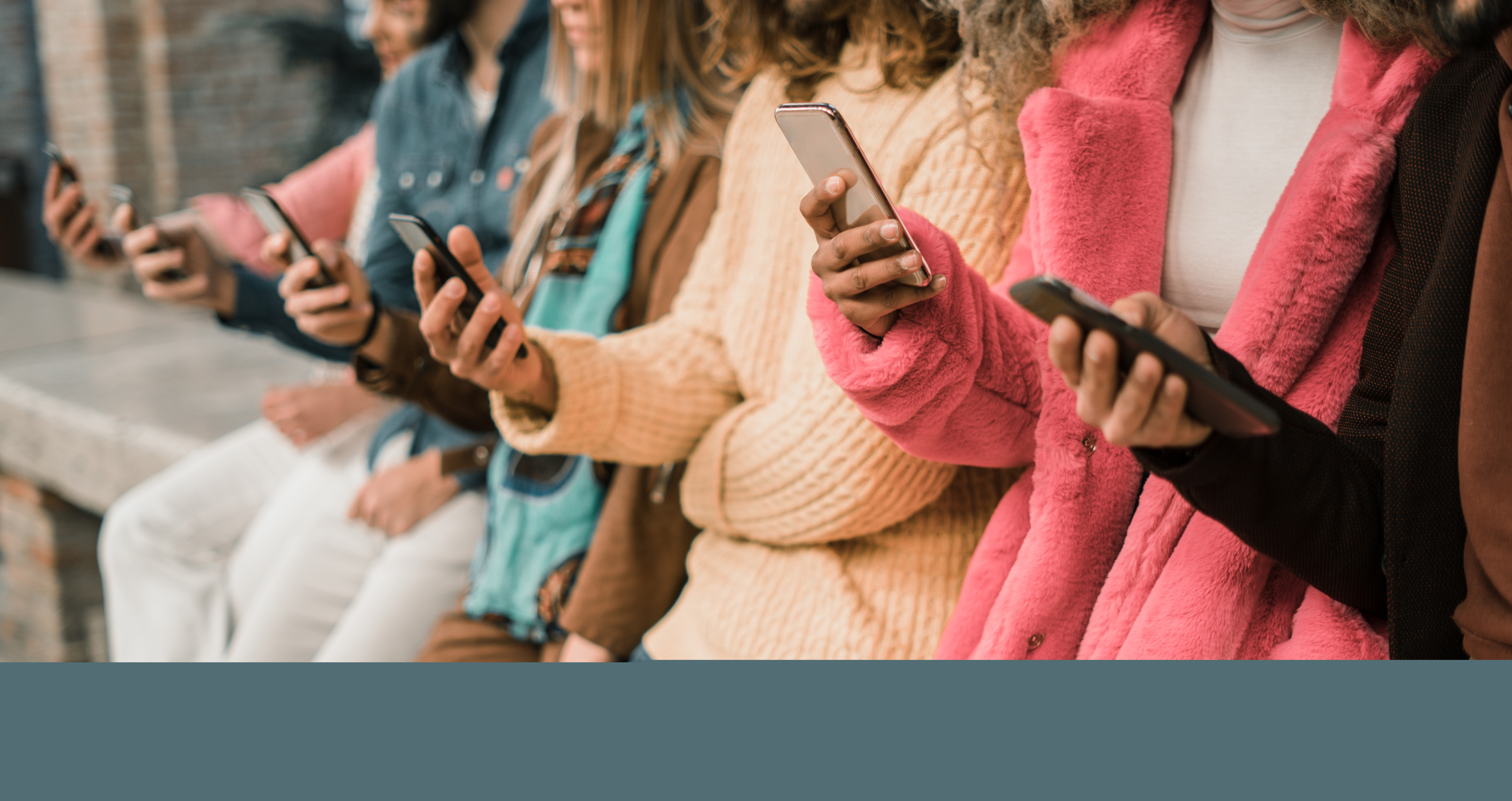 Ett gäng ungdomar står på rad med sina mobiltelefoner i handen.