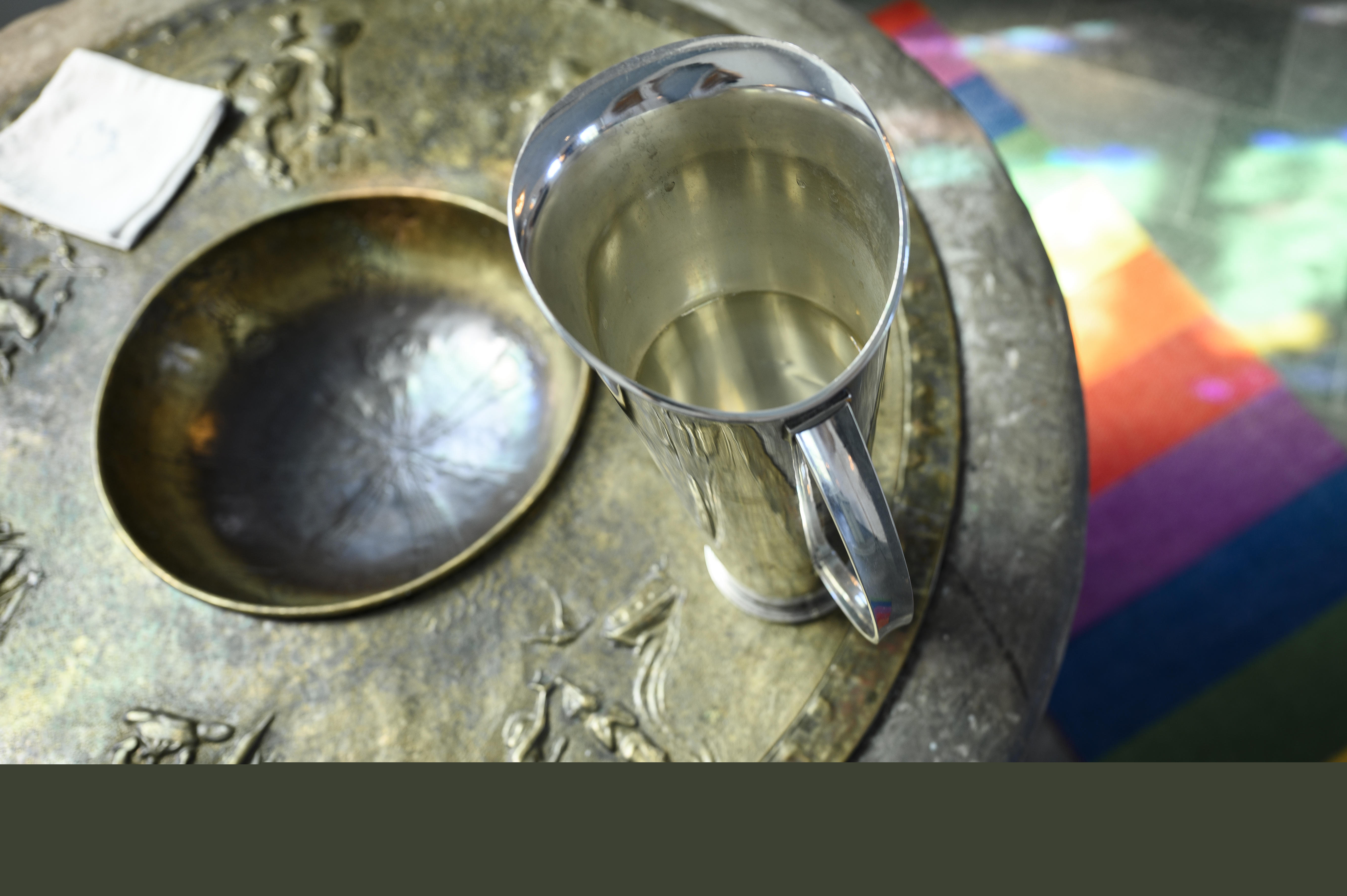 En kanna vatten står på en dopfunt.