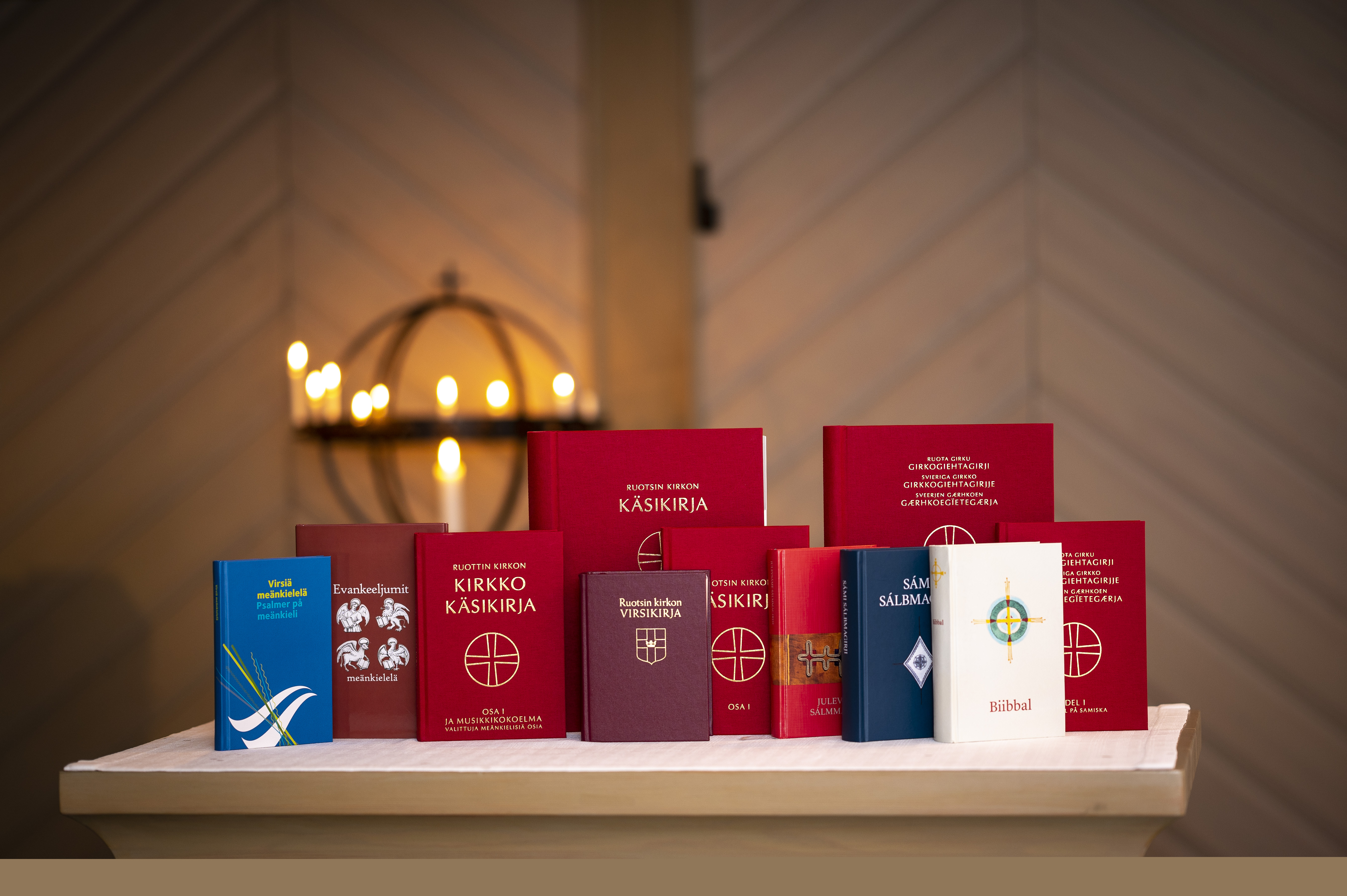 Olika kyrkliga publikationer på minoritetsspråk står uppställda på ett bord i en kyrka.