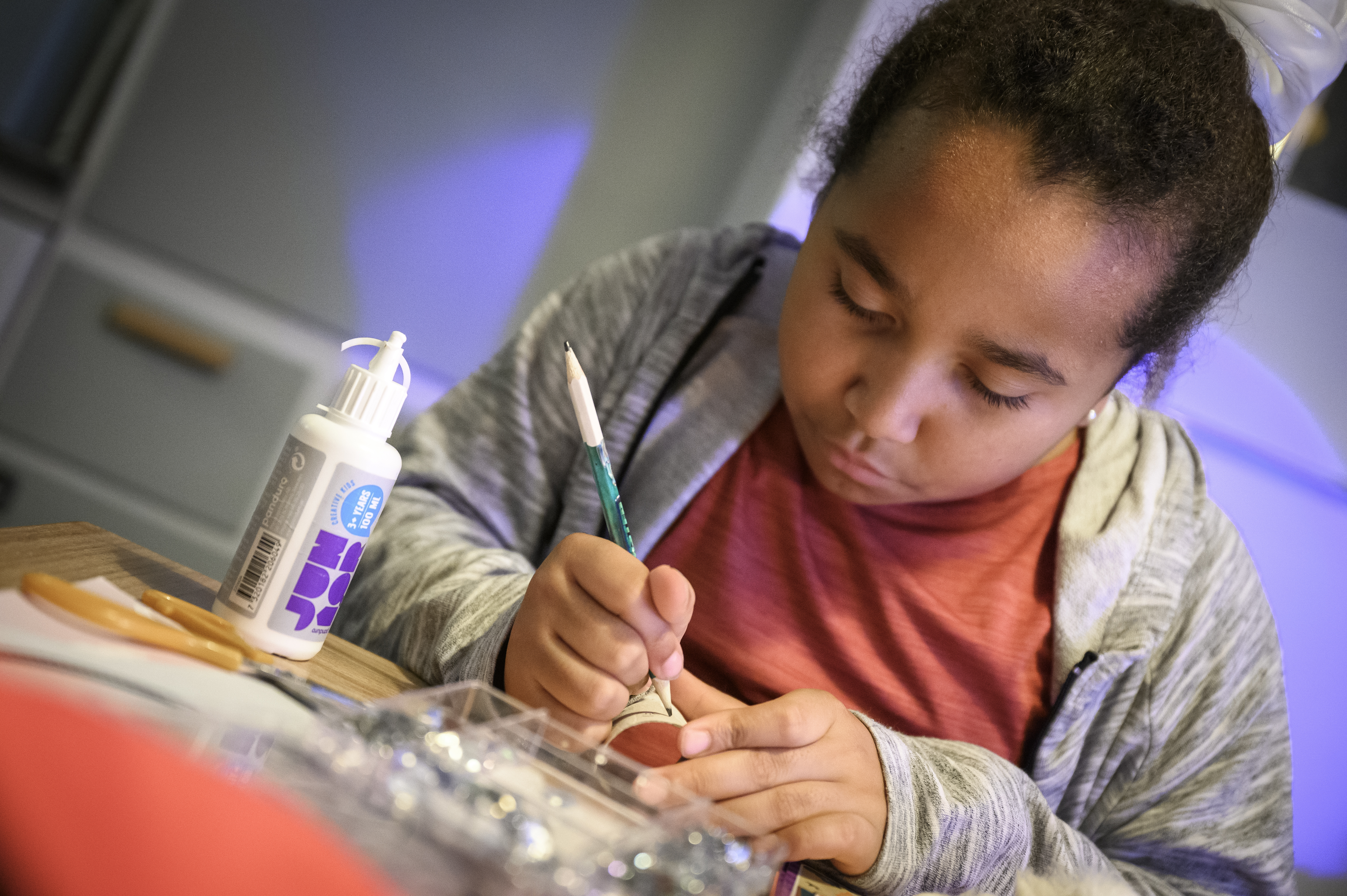 En flicka sitter och pysslar.