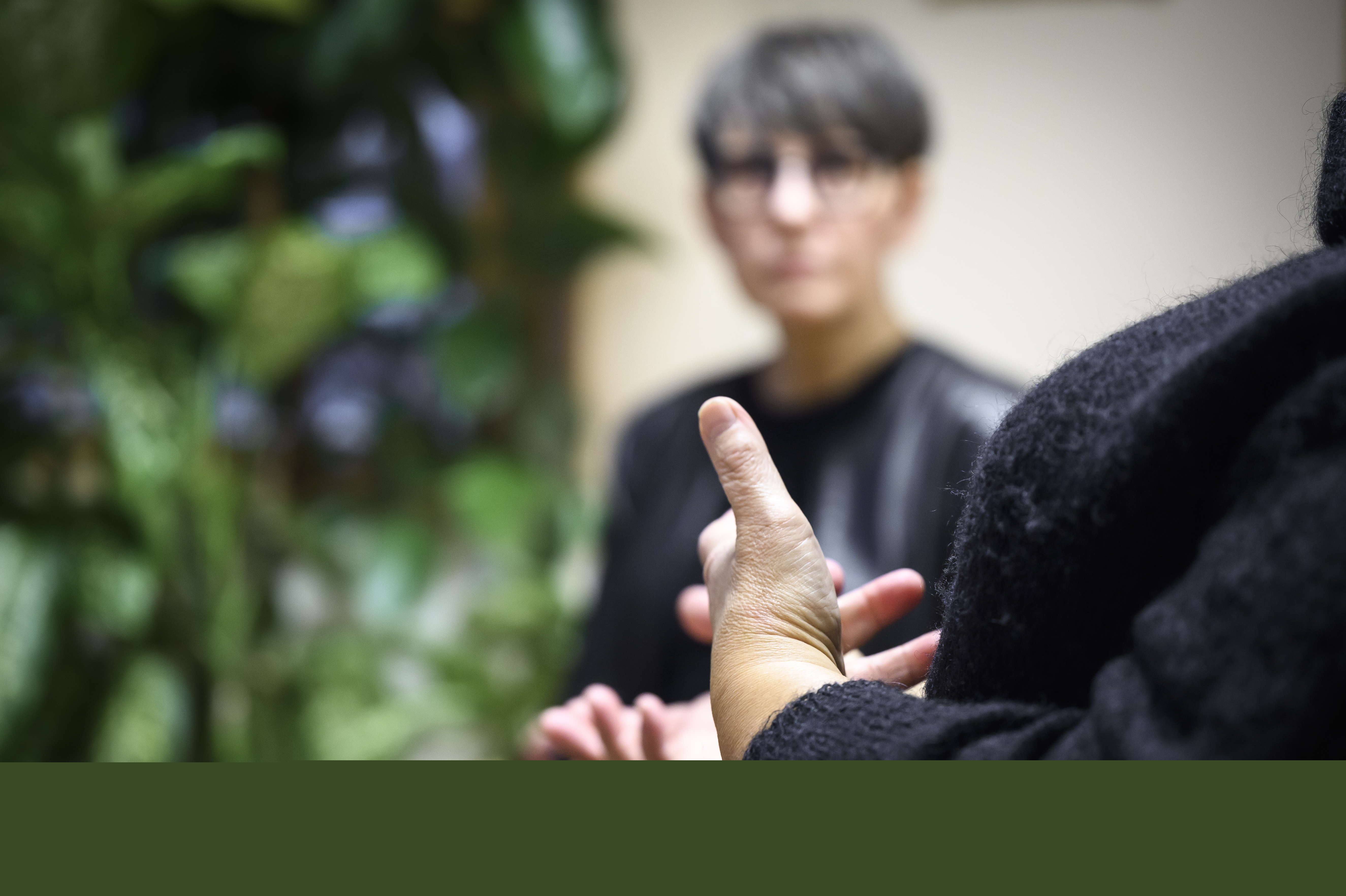 Två svartklädda personer sitter och samtalar.