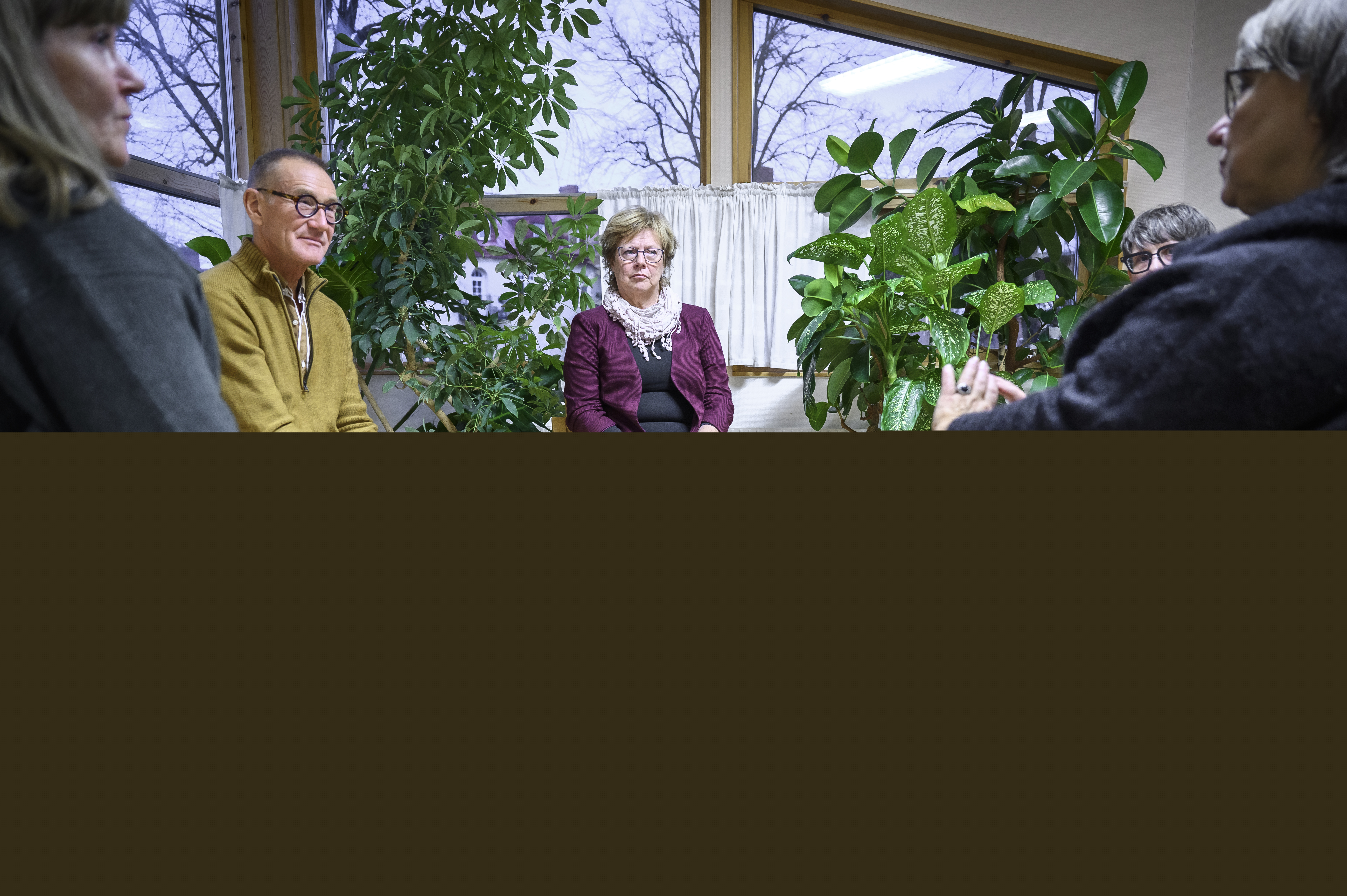 Några personer sitter och samtalar inomhus.