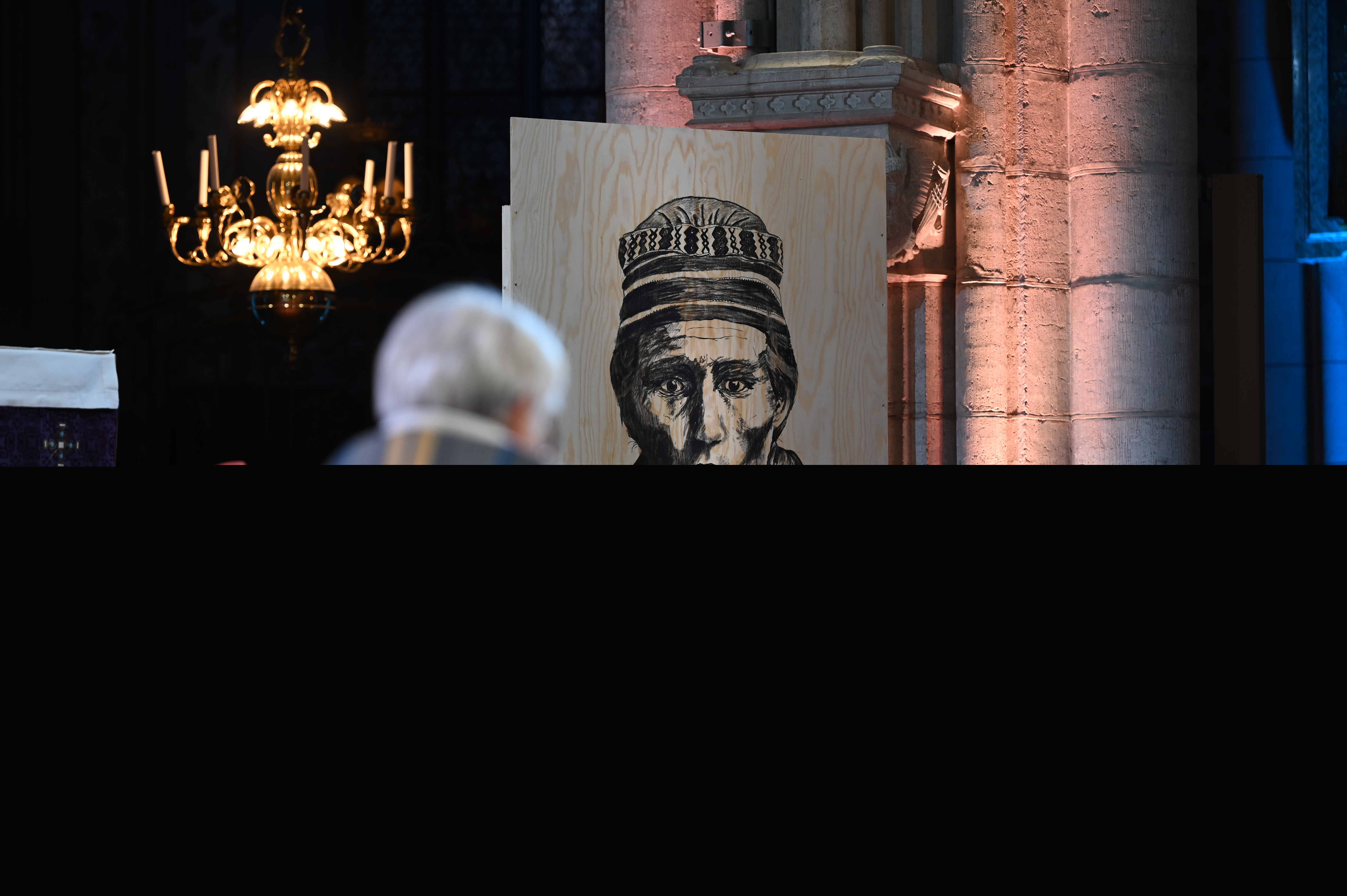 Ett svartvitt sameporträtt tryckt på en spånskiva står i Uppsala domkyrka.