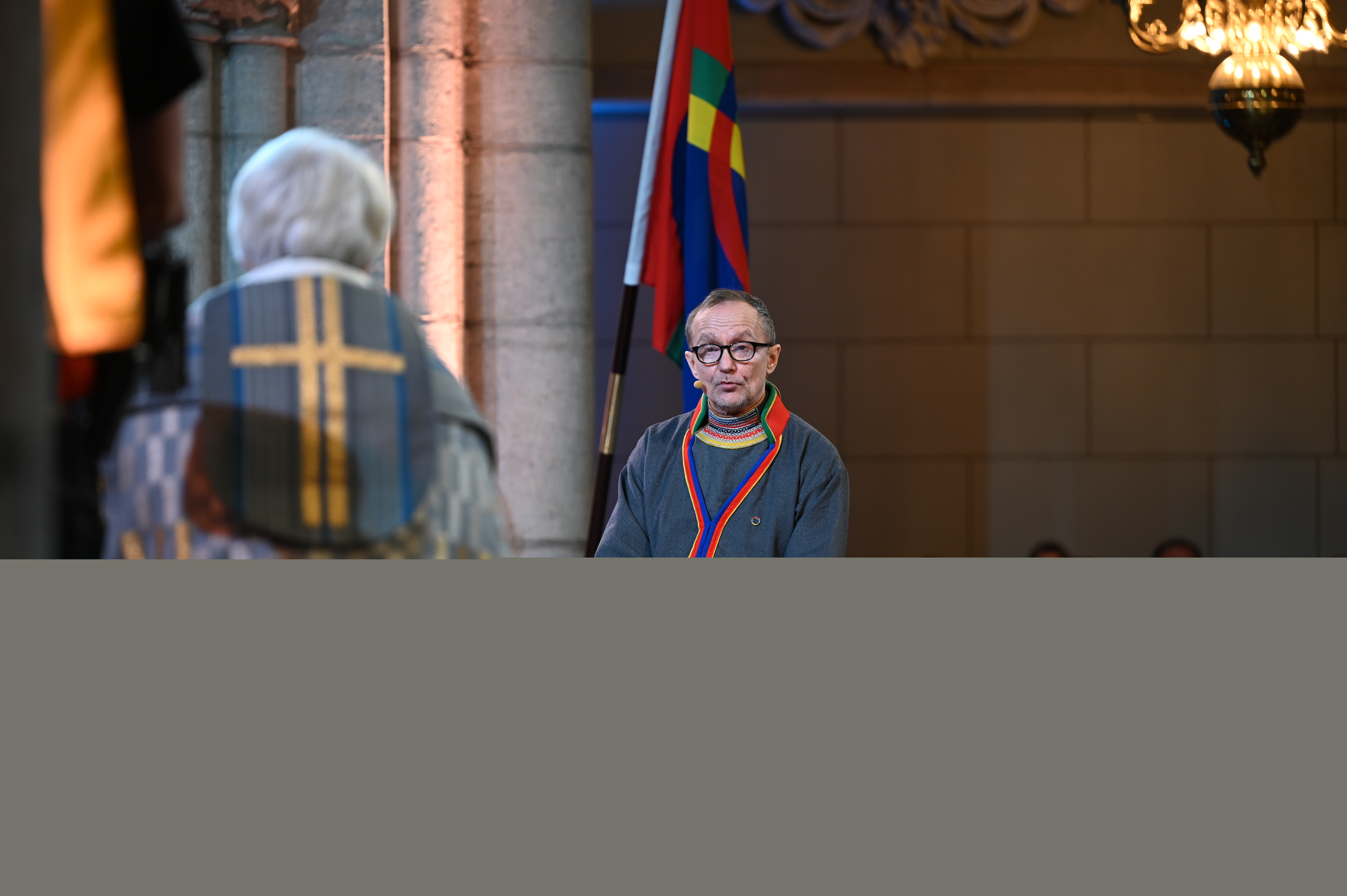 En man i samedräkt sitter mittemot ärkebiskop Antje Jackelén i Uppsala domkyrka.