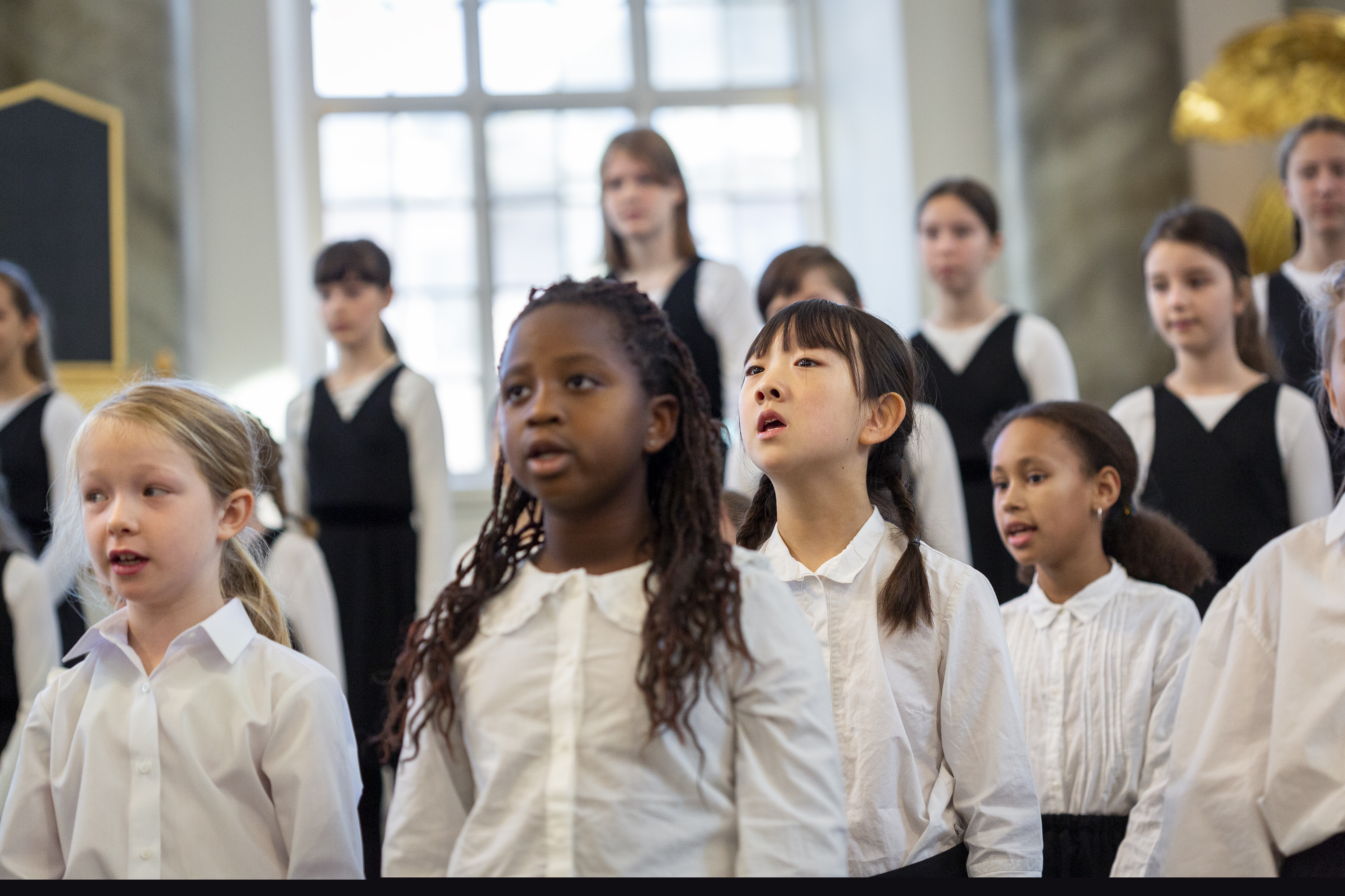 Några medlemmar i en barnkör som sjunger i en kyrka.