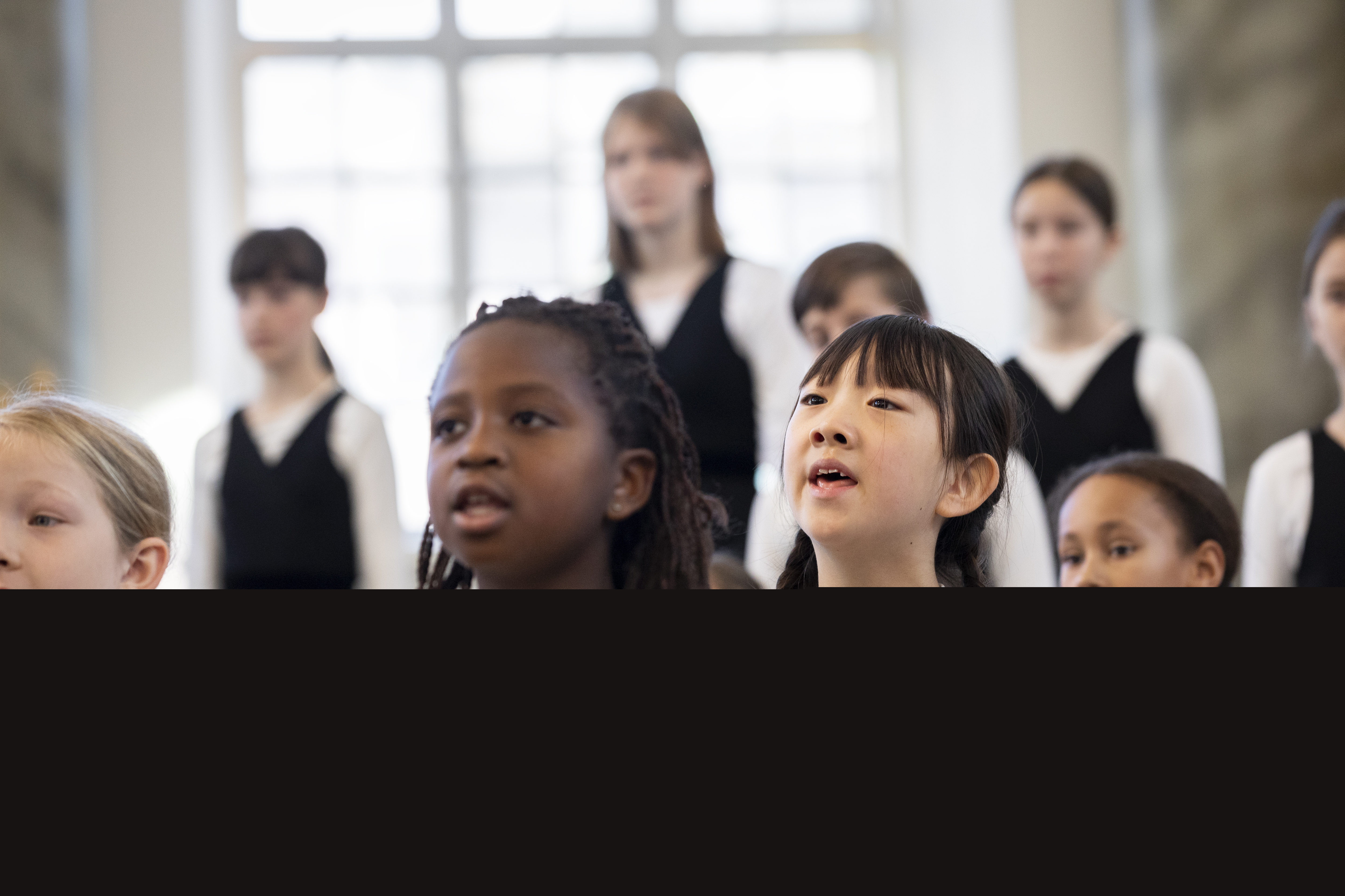 Medlemmar i en barnkör står och sjunger i en kyrka.