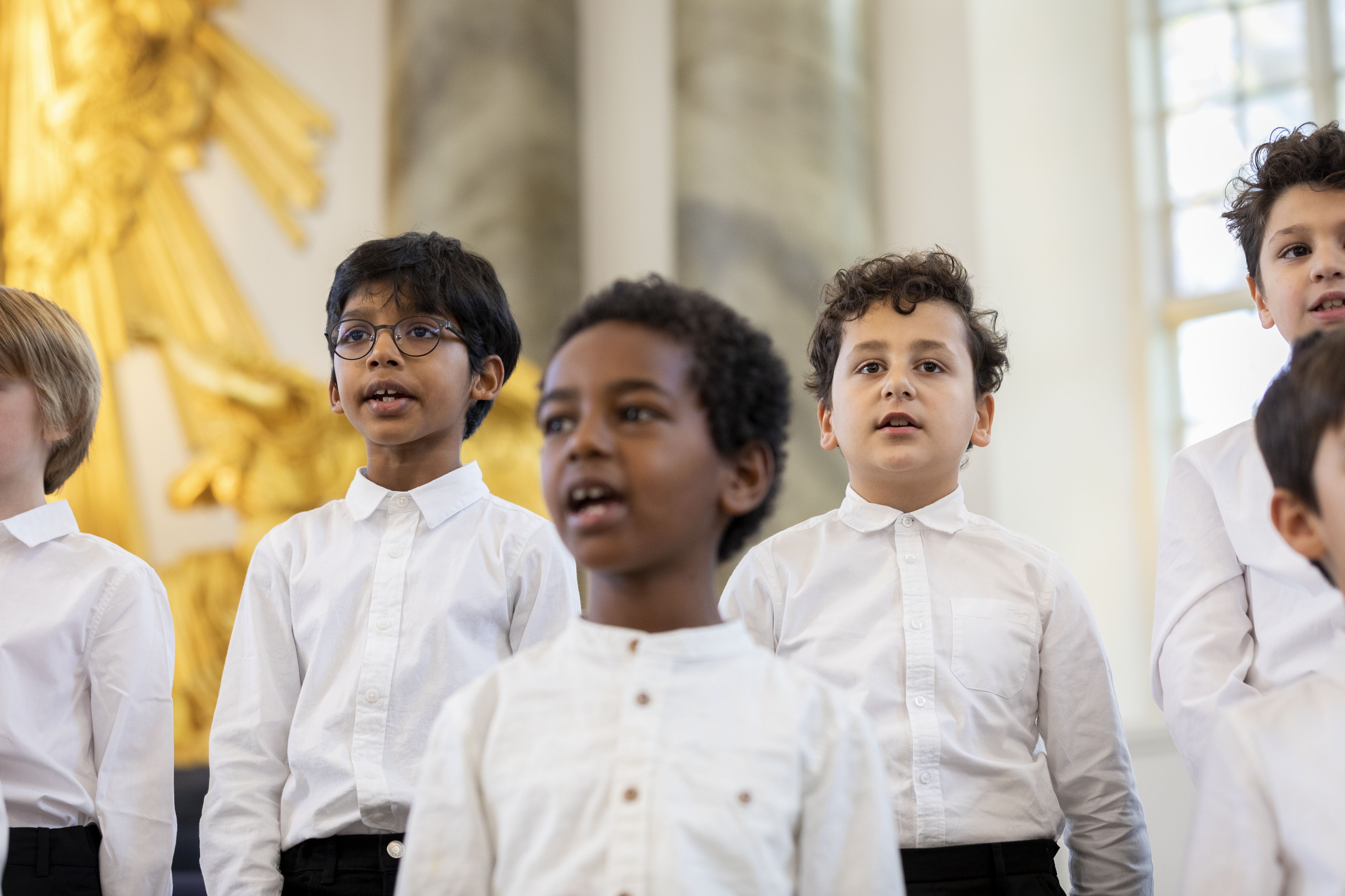 Medlemmar i en barnkör står och sjunger i en kyrka.