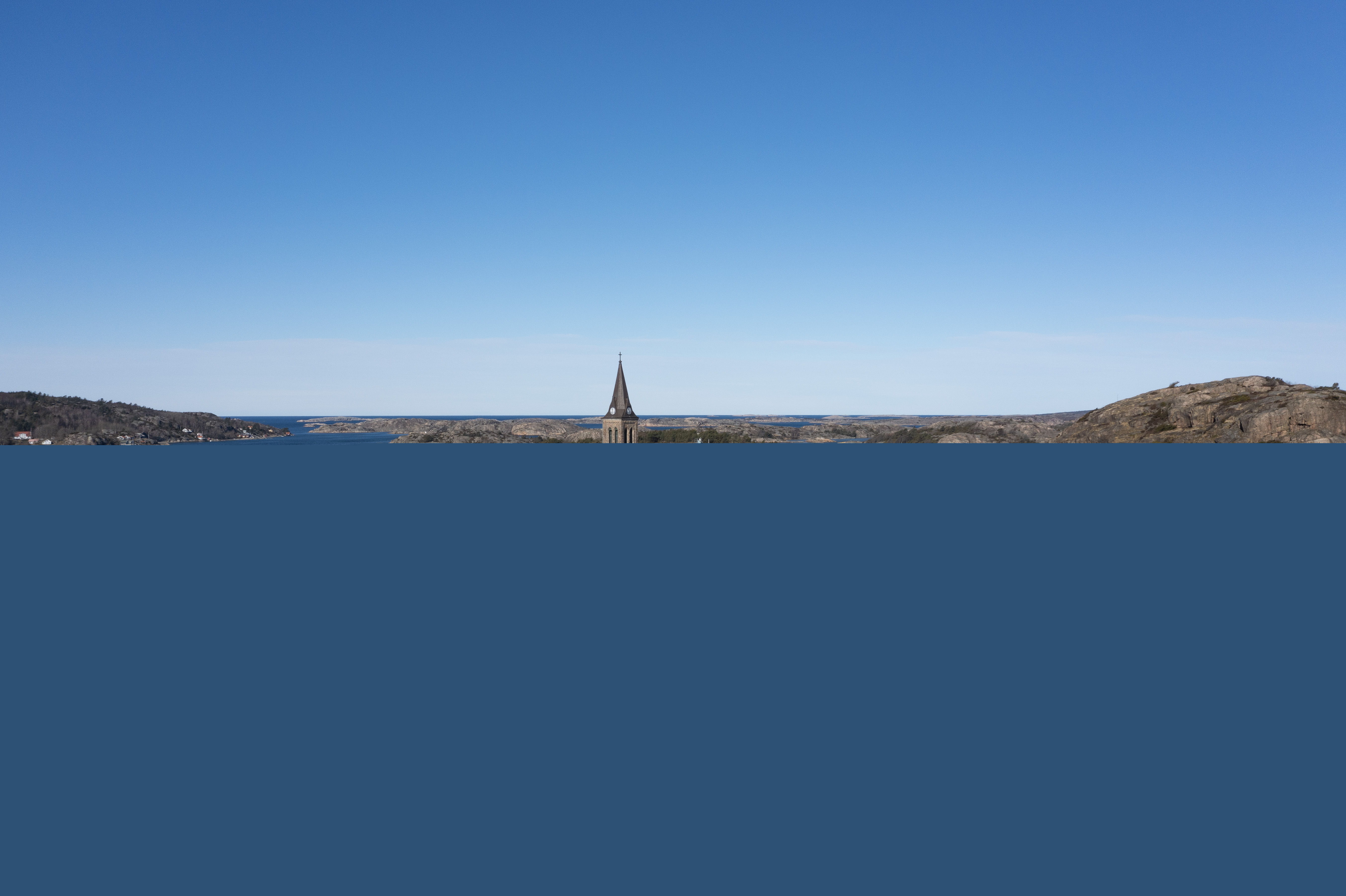 En stenkyrka i en fiskeby vid havet.