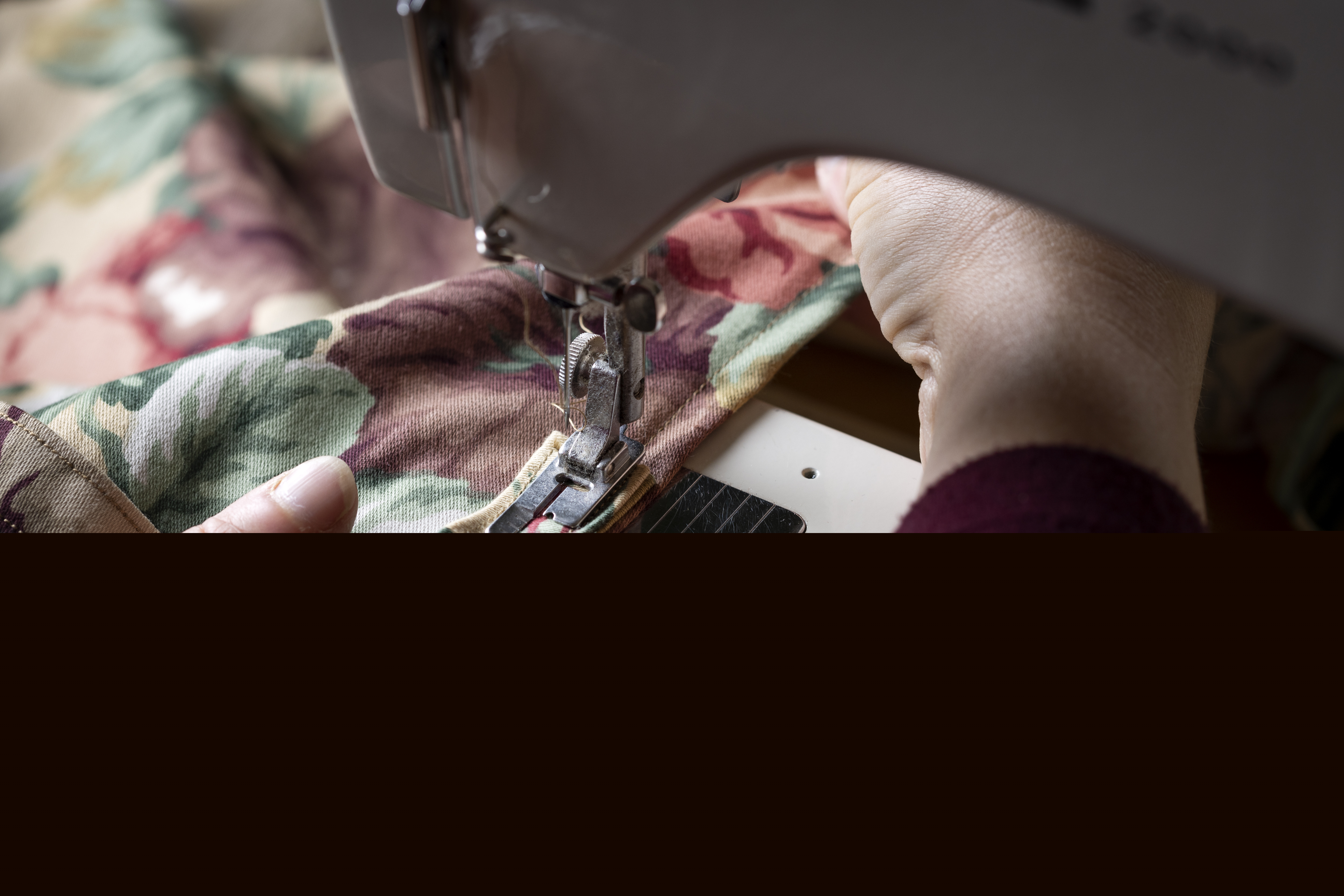 Närbild på någon som syr på en symaskin.
