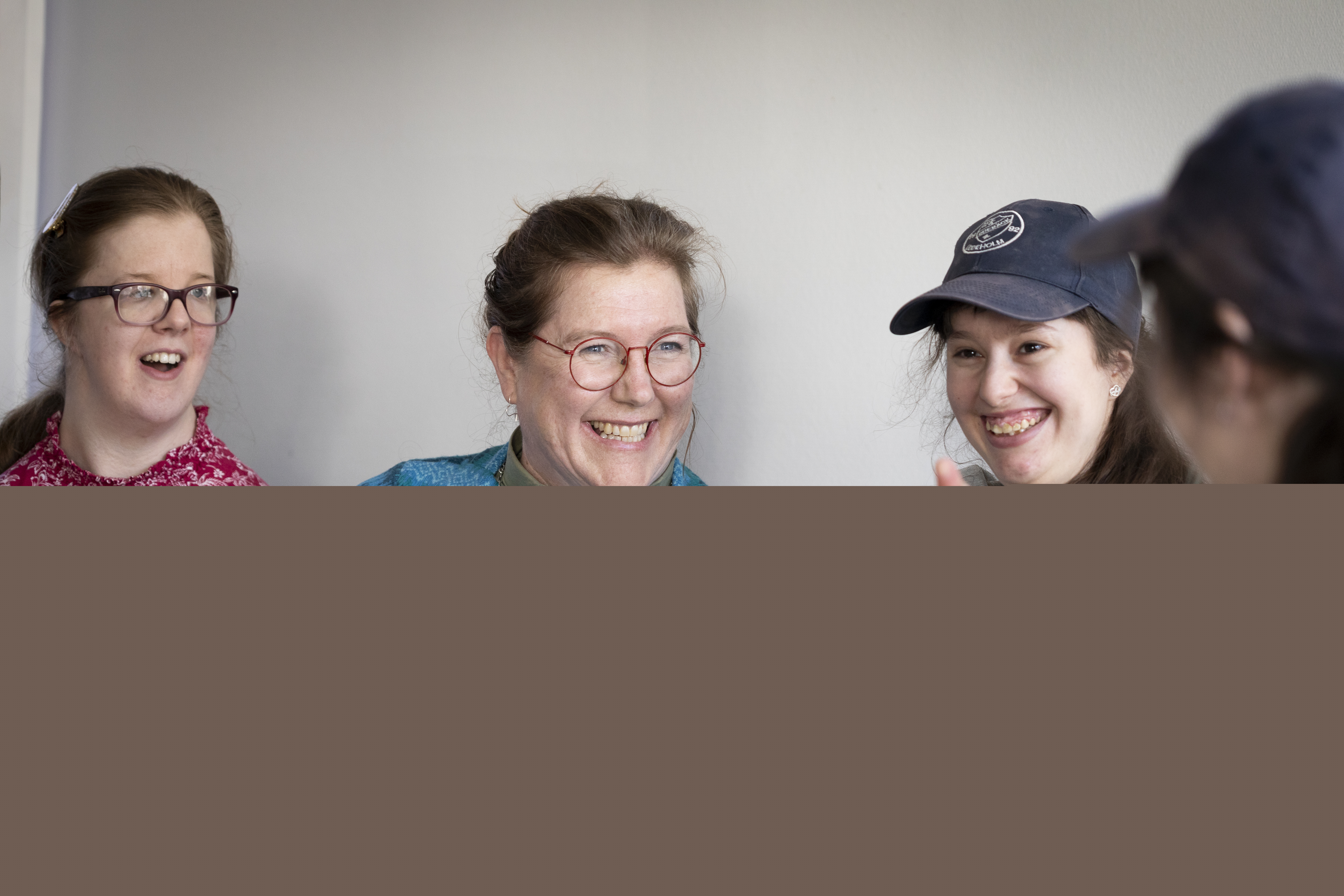 En kvinnlig diakon sitter och pratar med ett gäng ungdomar.