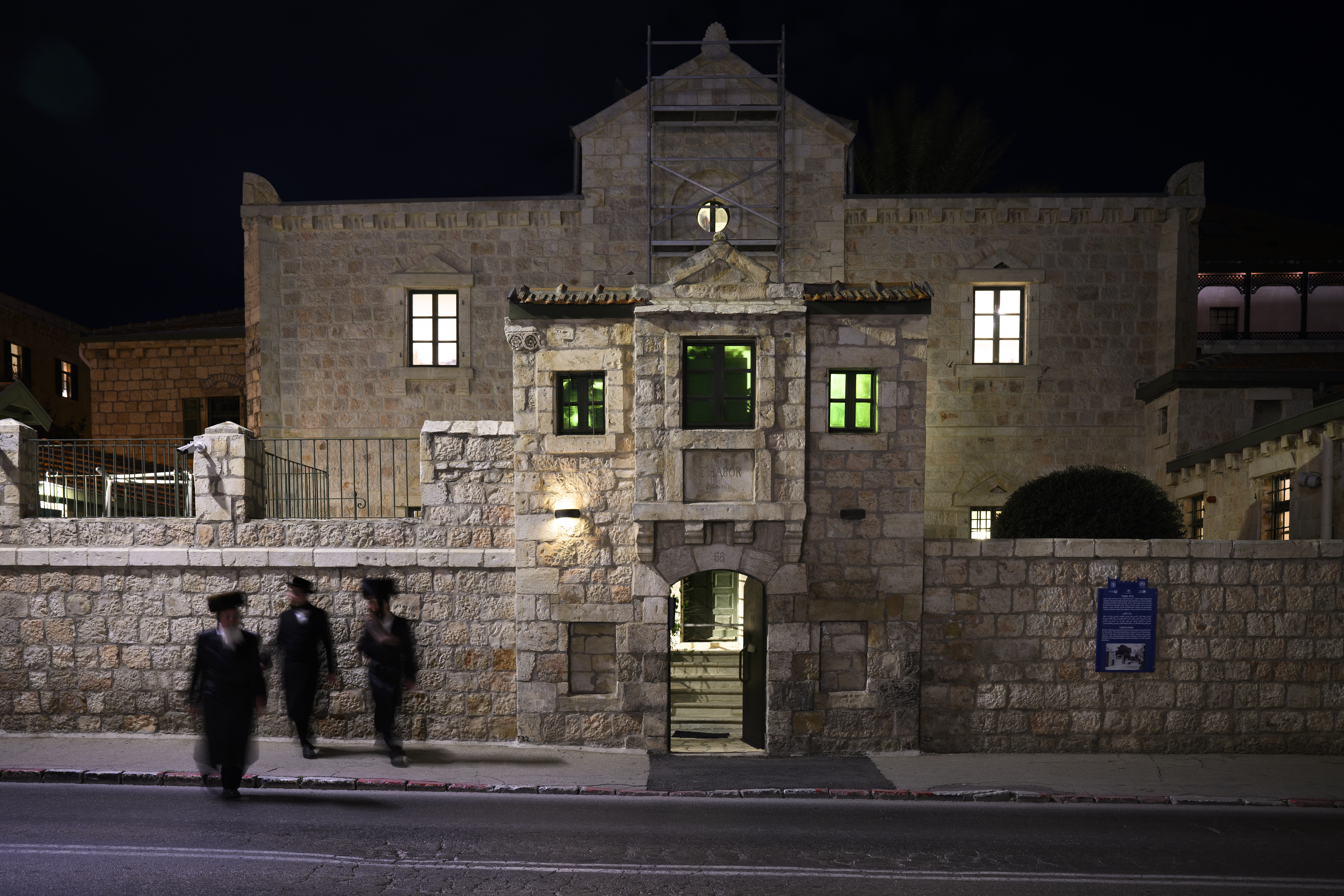 Ett gammalt stenhus i flera våningar, omgivet av en fästningsliknande mur.